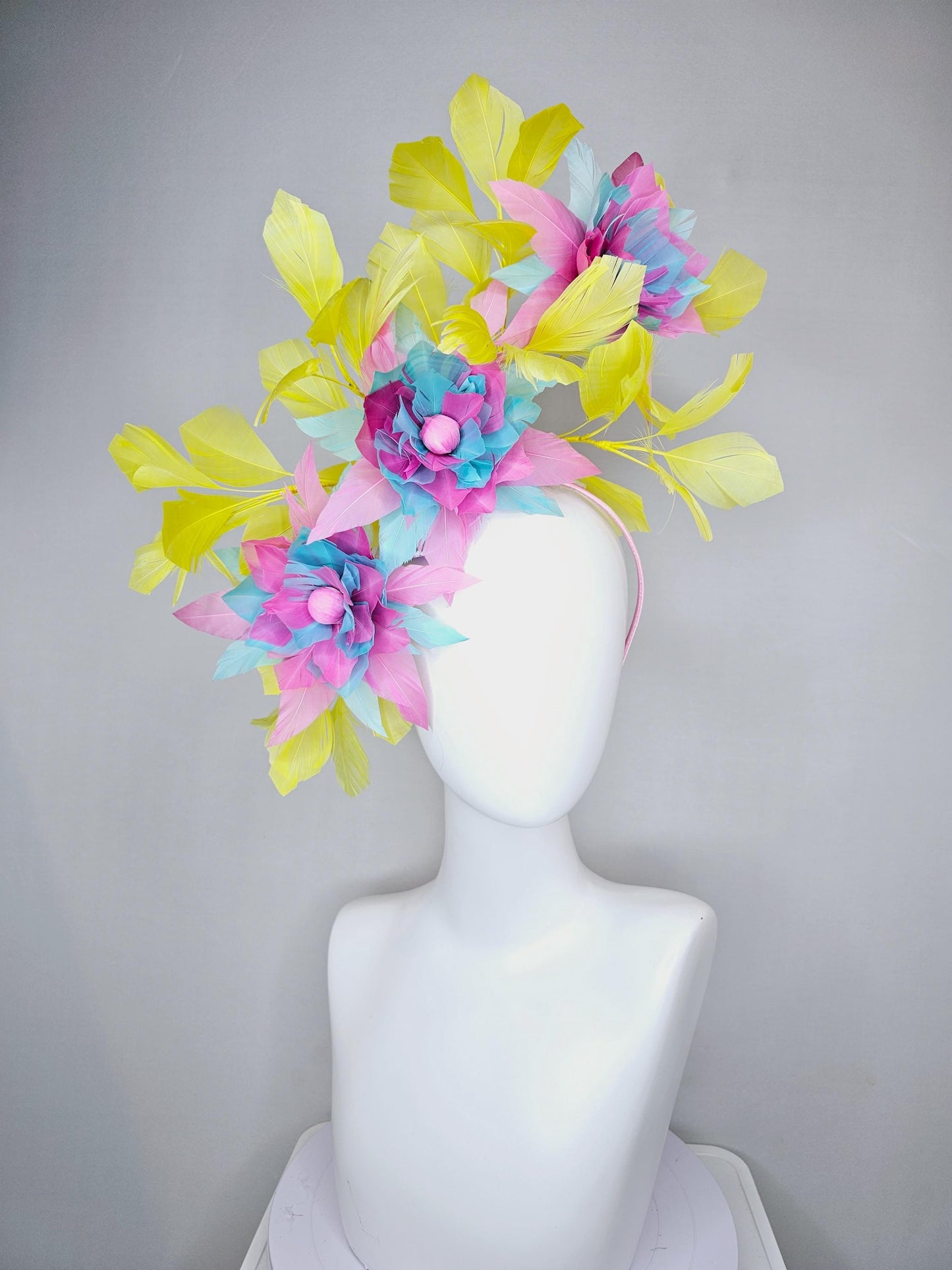 kentucky derby hat fascinator with large blush pink and baby sky blue feather flowers and yellow branching feathers