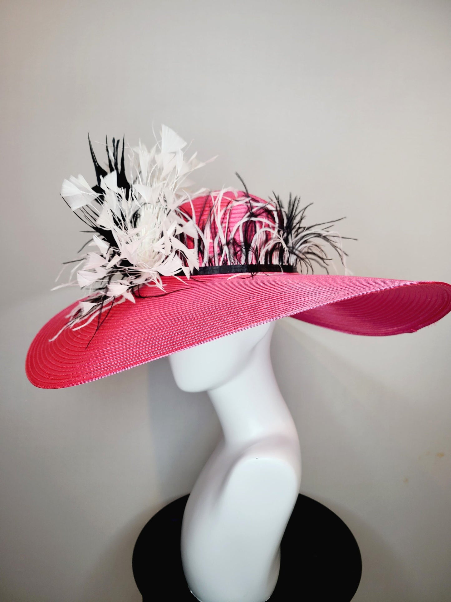 kentucky derby hat super wide brim bright pink fuchsia satin hat with black and white feather trim and black and white feather decor