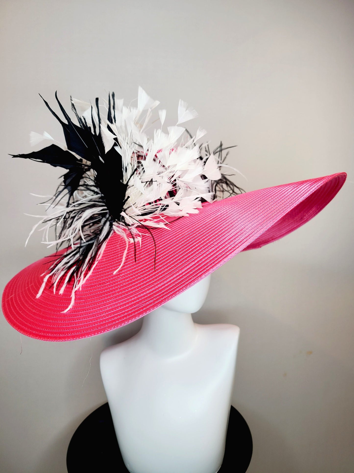 kentucky derby hat super wide brim bright pink fuchsia satin hat with black and white feather trim and black and white feather decor