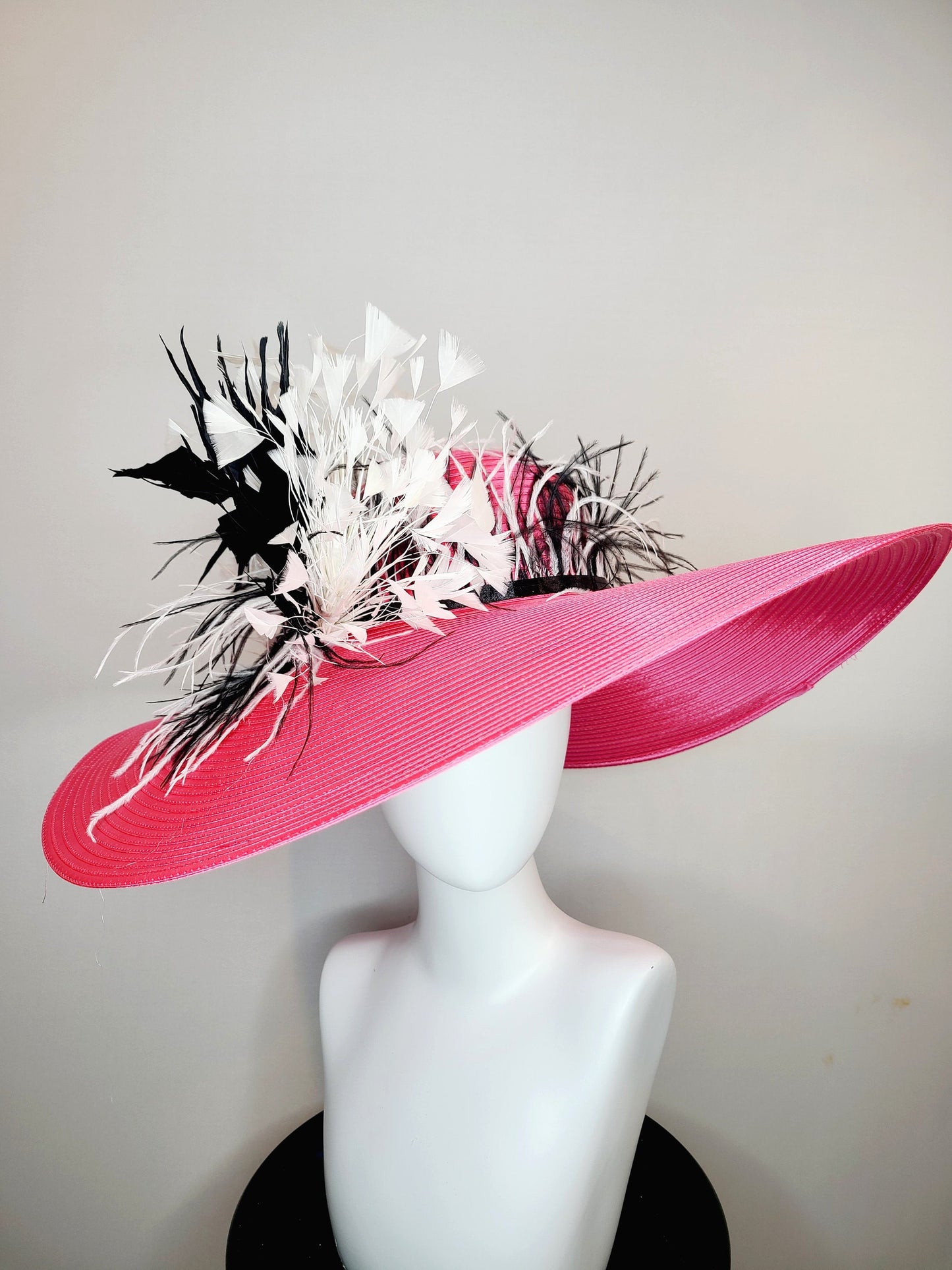 kentucky derby hat super wide brim bright pink fuchsia satin hat with black and white feather trim and black and white feather decor