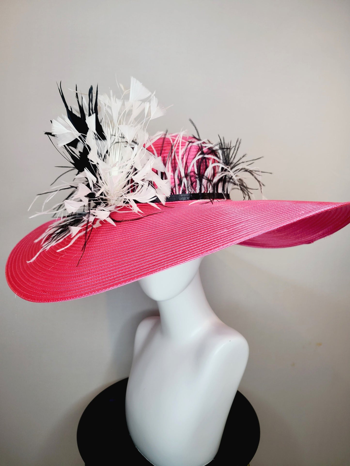 kentucky derby hat super wide brim bright pink fuchsia satin hat with black and white feather trim and black and white feather decor