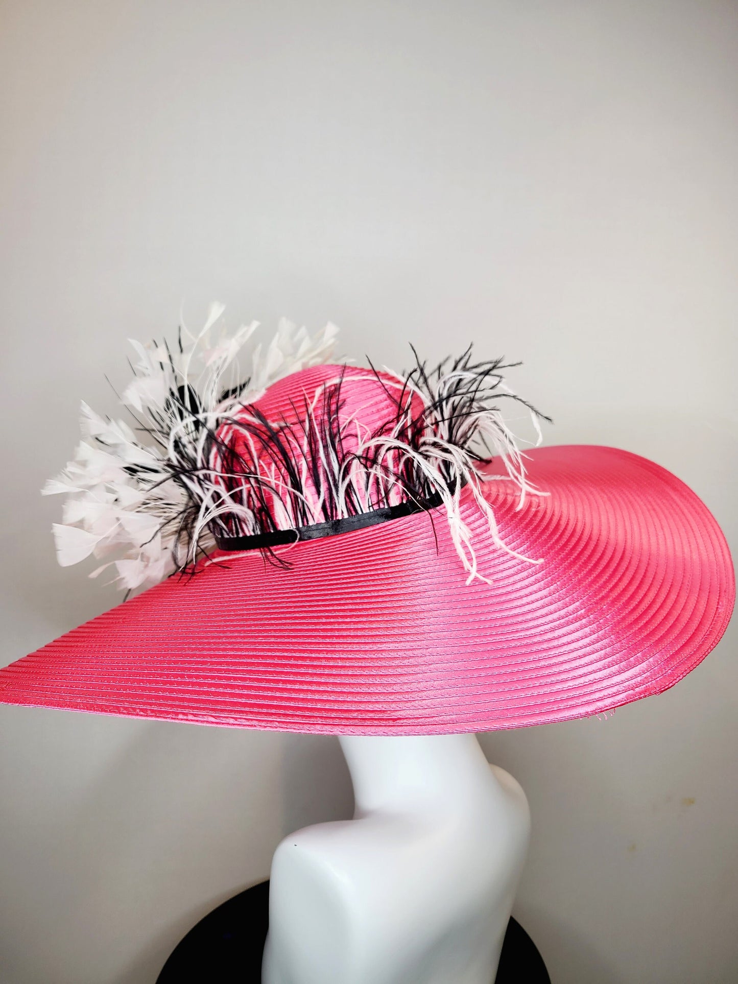 kentucky derby hat super wide brim bright pink fuchsia satin hat with black and white feather trim and black and white feather decor