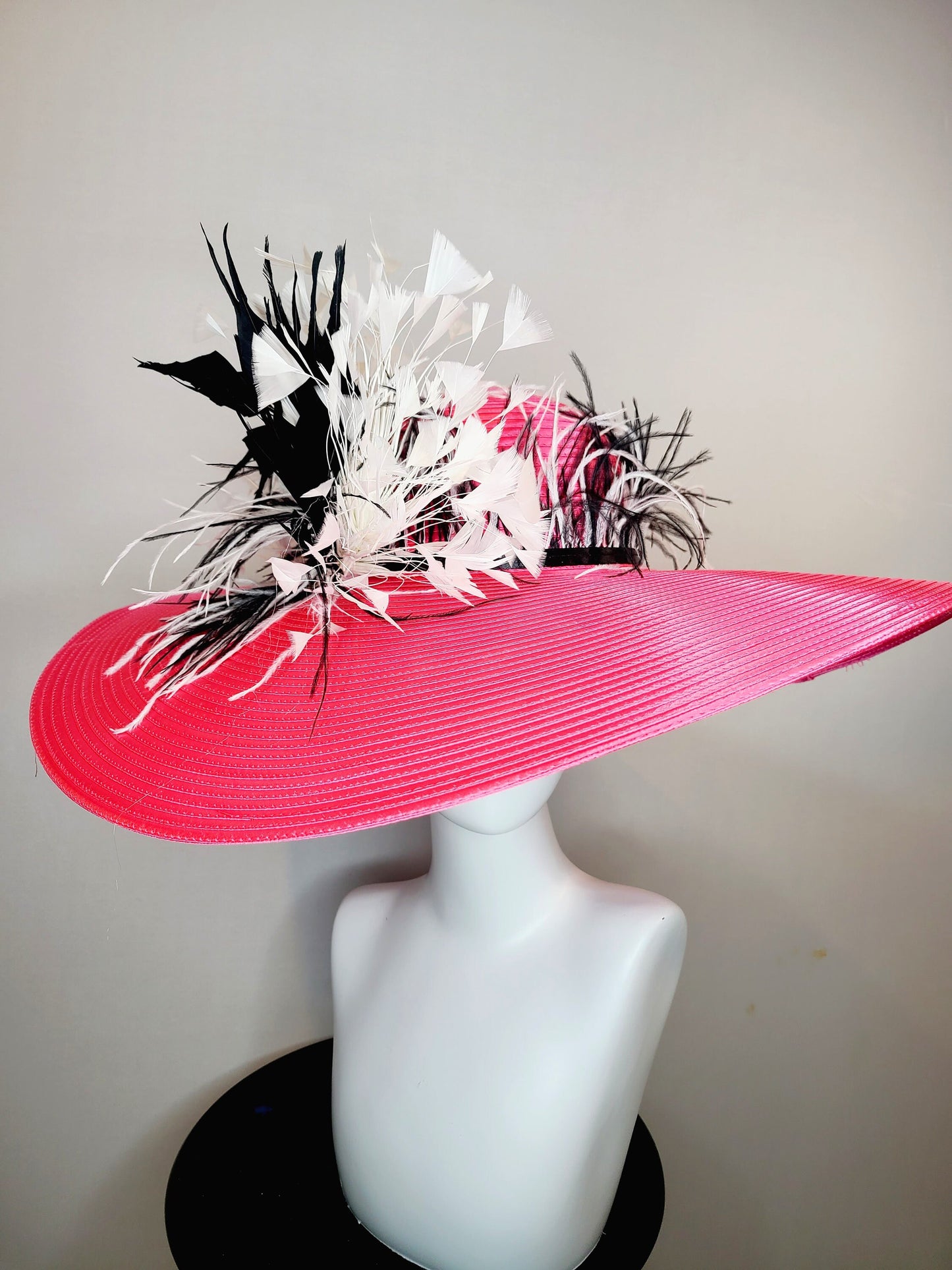 kentucky derby hat super wide brim bright pink fuchsia satin hat with black and white feather trim and black and white feather decor