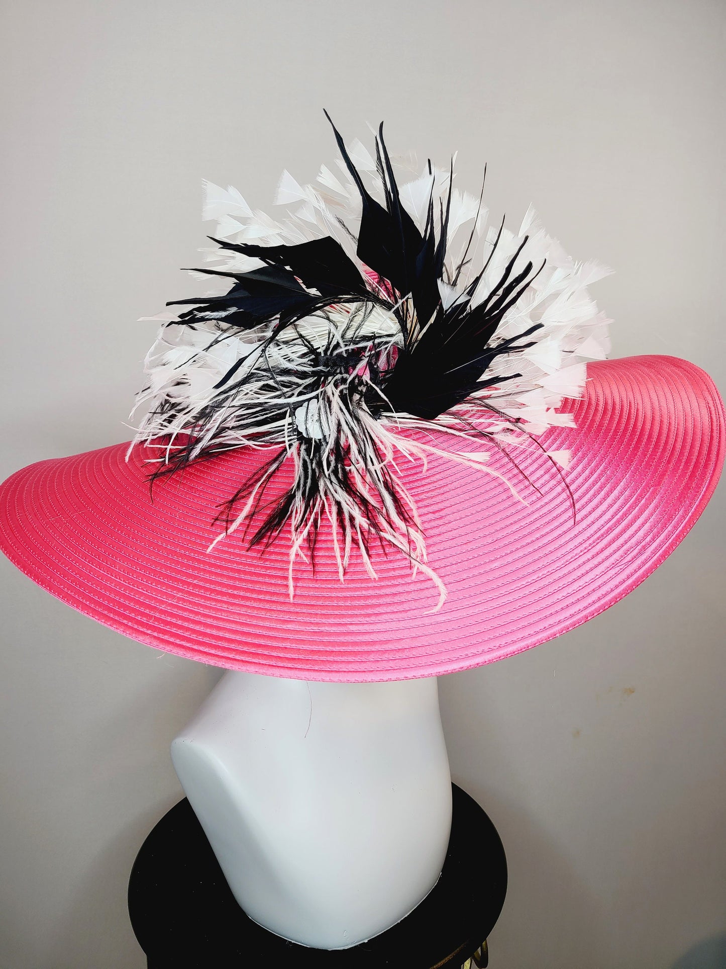 kentucky derby hat super wide brim bright pink fuchsia satin hat with black and white feather trim and black and white feather decor