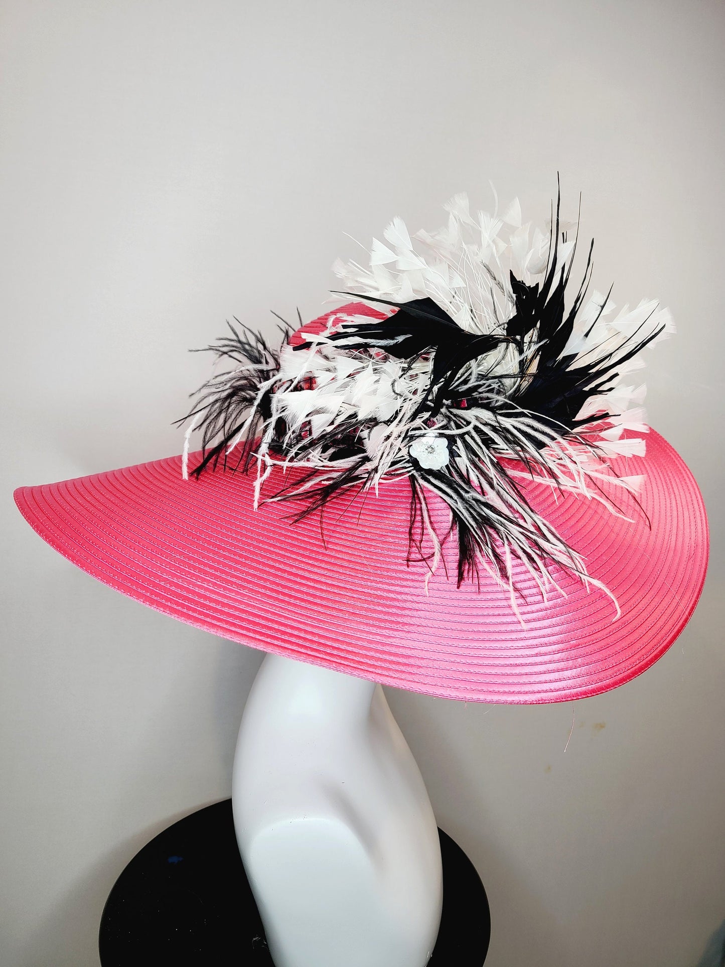 kentucky derby hat super wide brim bright pink fuchsia satin hat with black and white feather trim and black and white feather decor