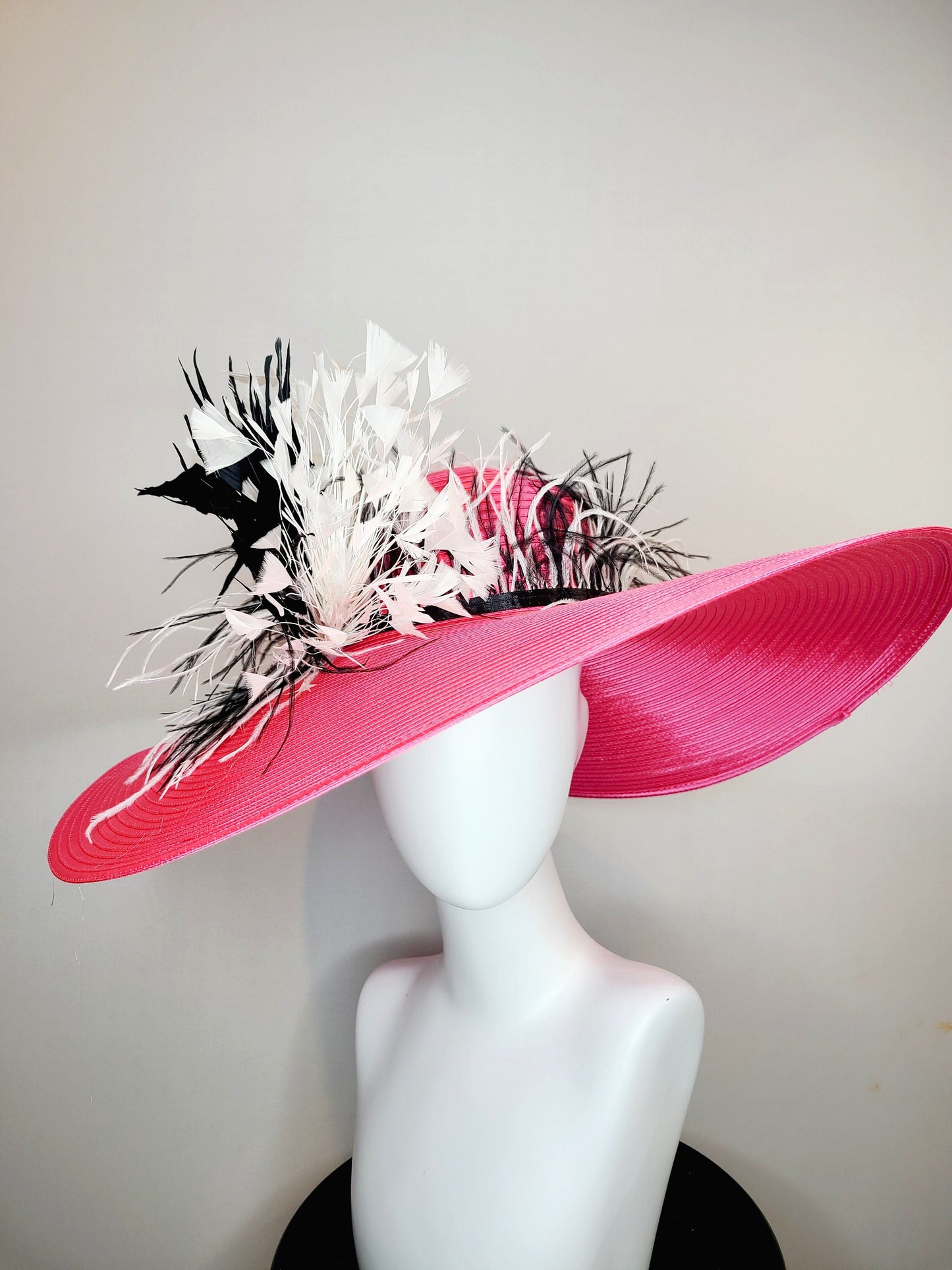 kentucky derby hat super wide brim bright pink fuchsia satin hat with black and white feather trim and black and white feather decor