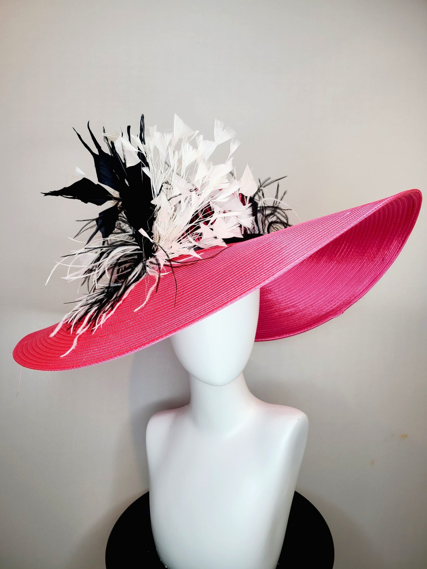 kentucky derby hat super wide brim bright pink fuchsia satin hat with black and white feather trim and black and white feather decor