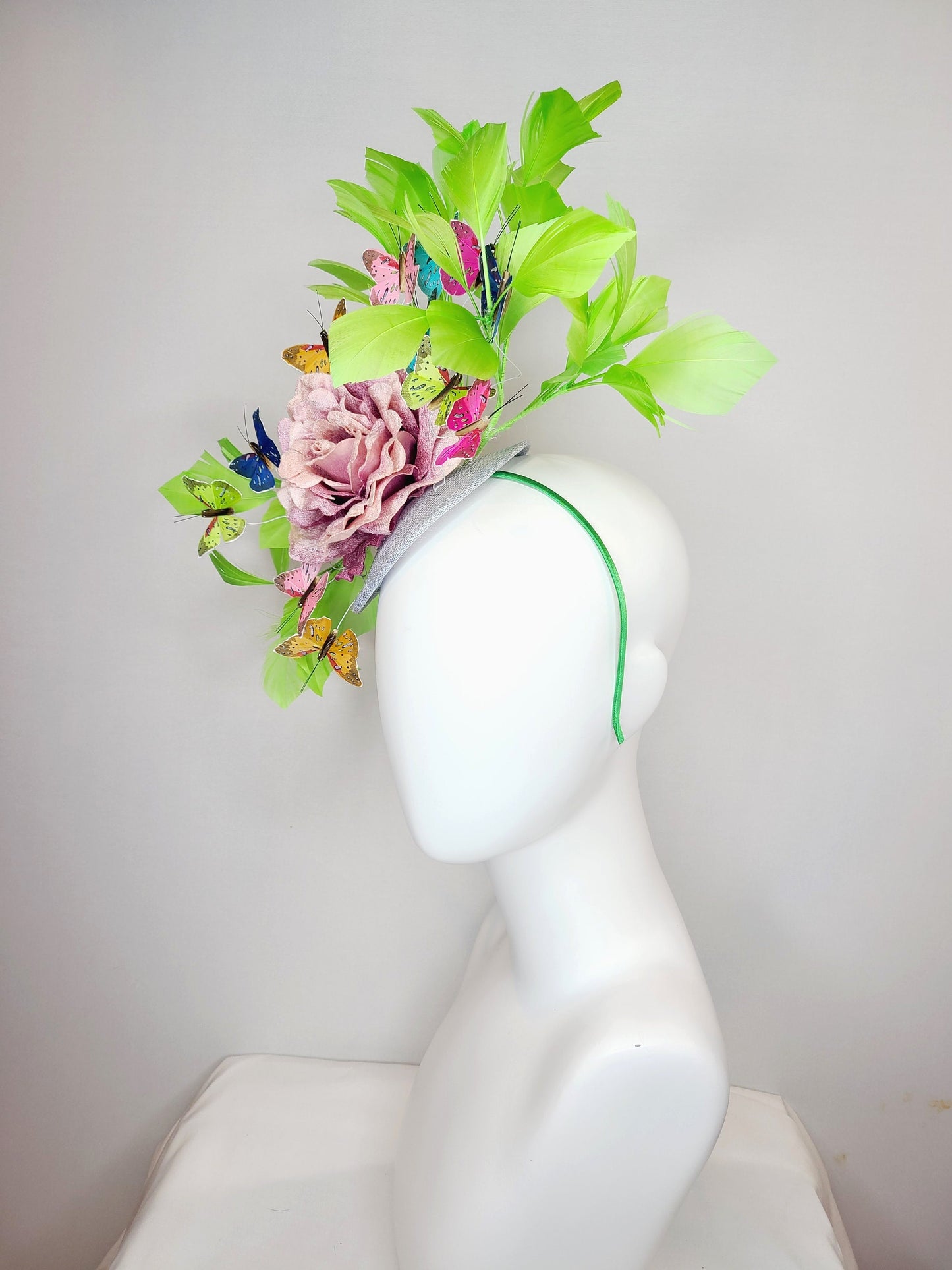 kentucky derby hat fascinator bright green feathers with mauve light pink rose rainbow pink yellow green blue decor and butterflies