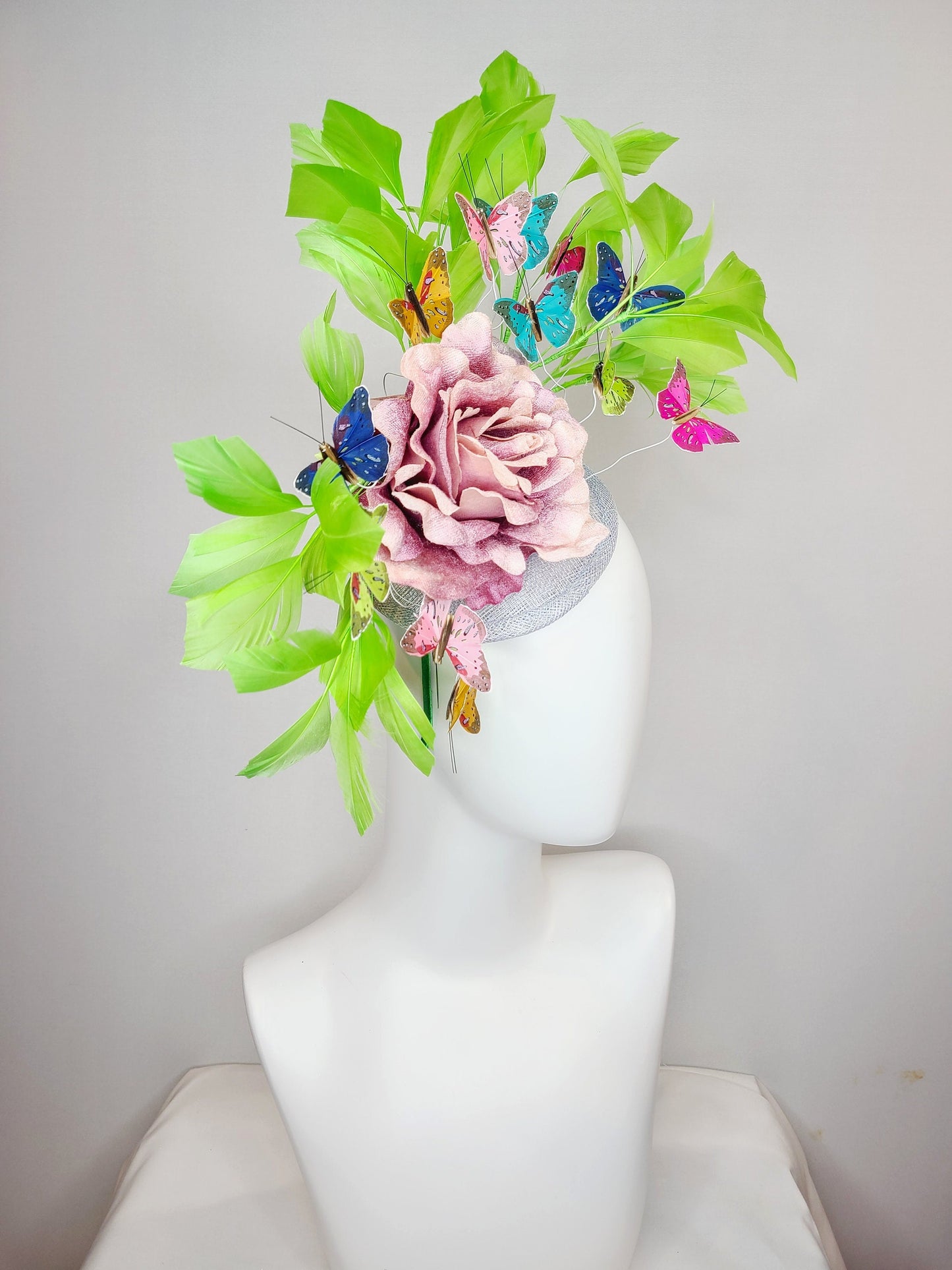 kentucky derby hat fascinator bright green feathers with mauve light pink rose rainbow pink yellow green blue decor and butterflies