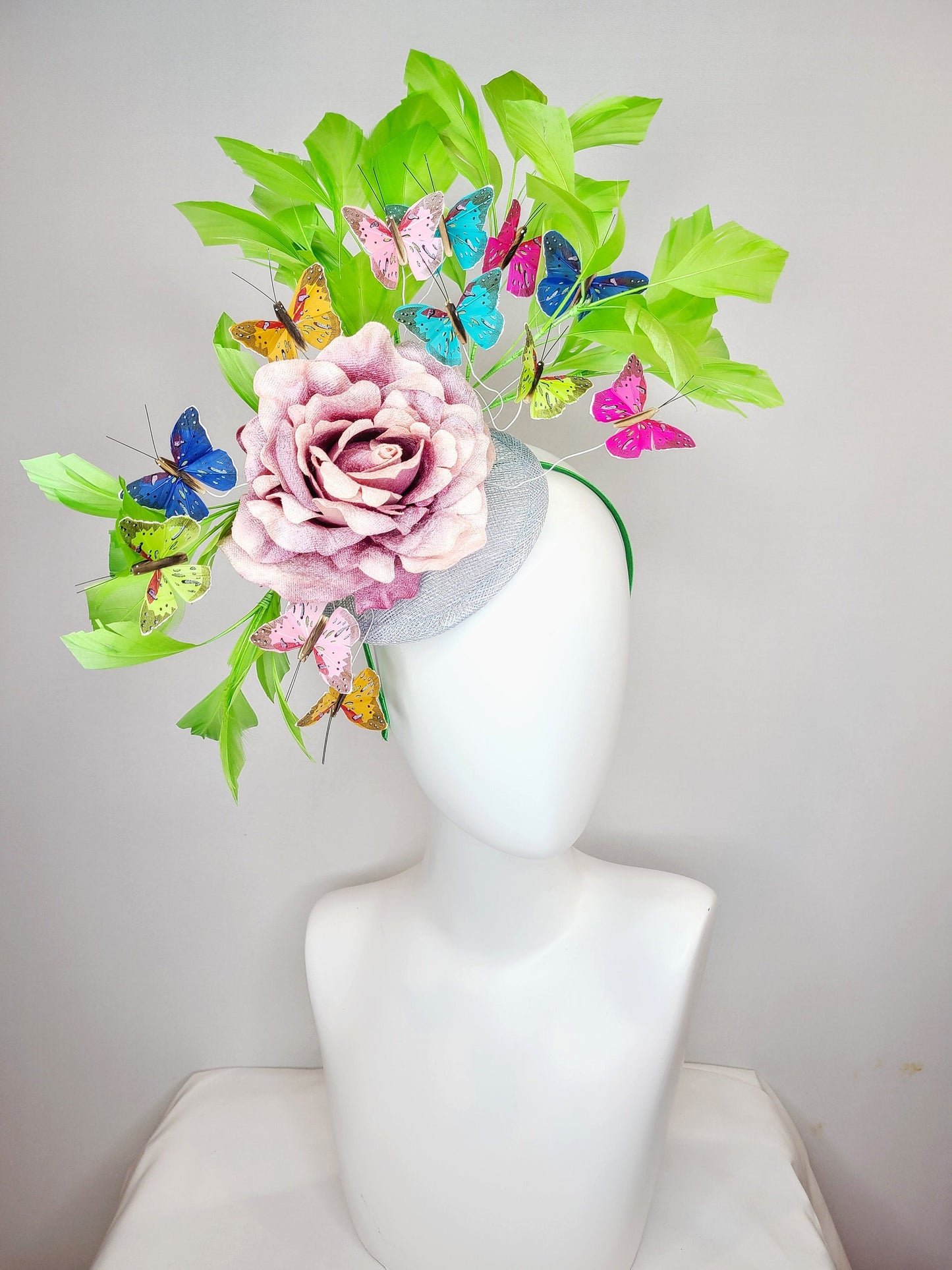 kentucky derby hat fascinator bright green feathers with mauve light pink rose rainbow pink yellow green blue decor and butterflies