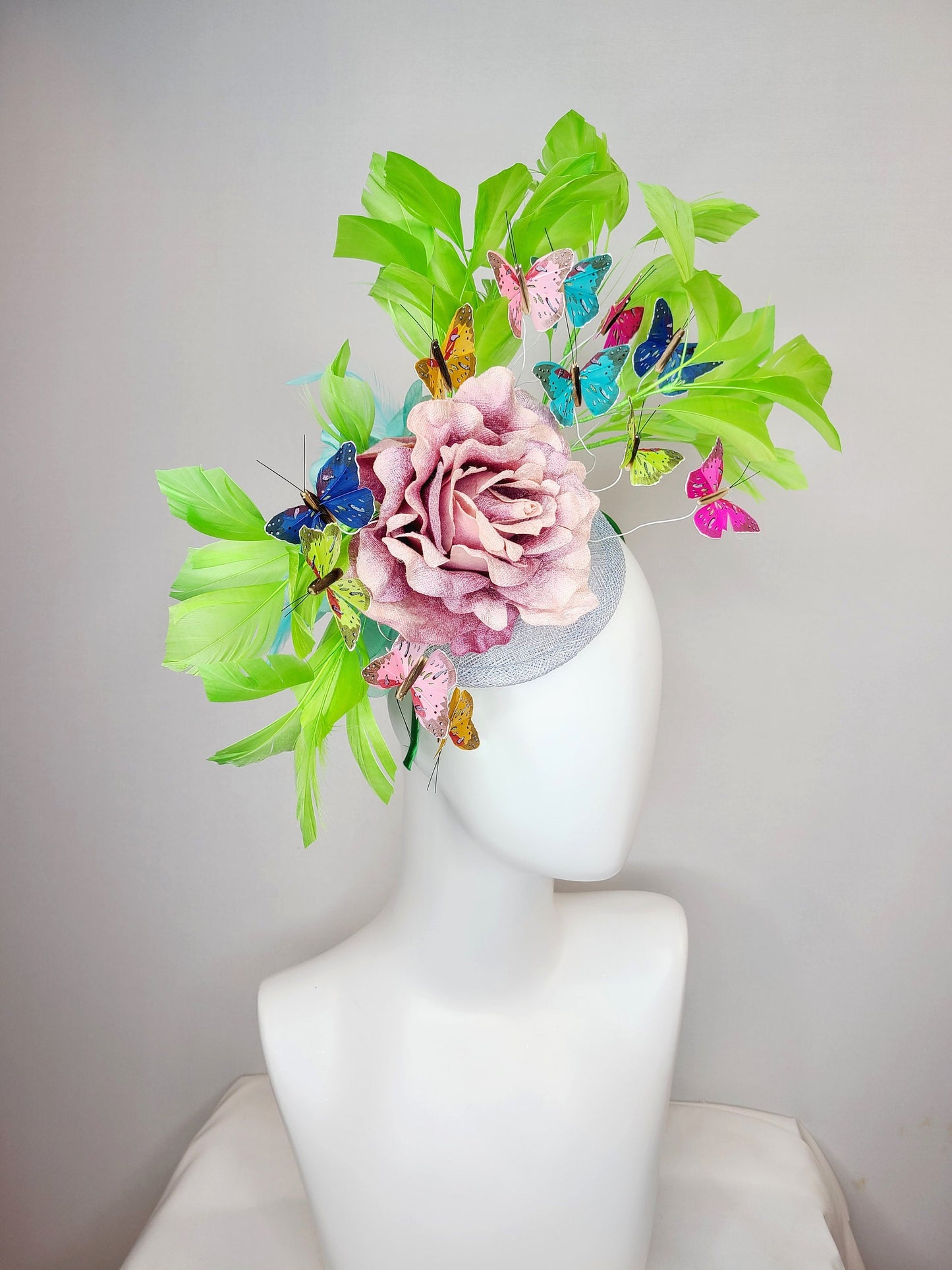 kentucky derby hat fascinator bright green feathers with mauve light pink rose rainbow pink yellow green blue decor and butterflies