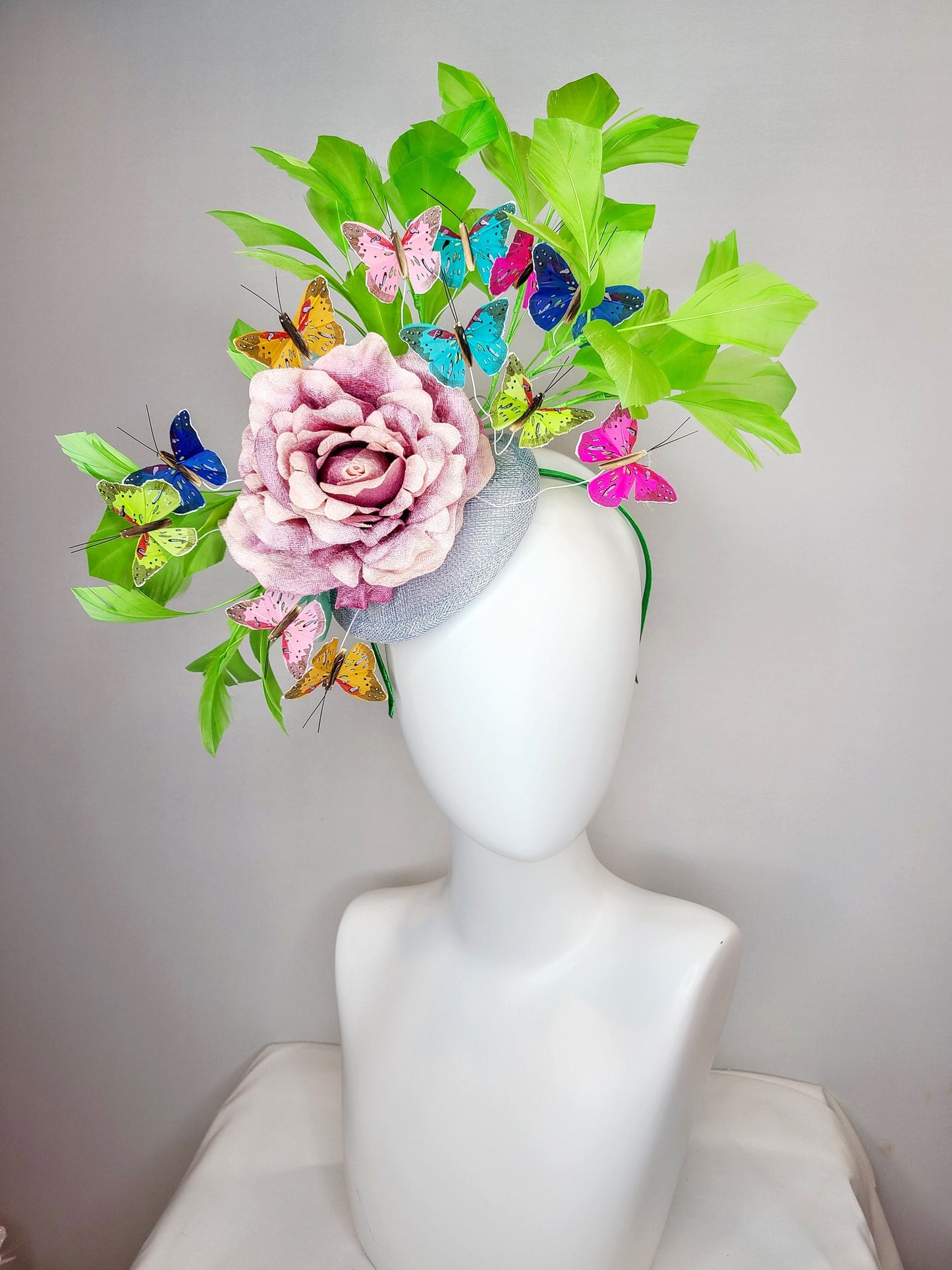 kentucky derby hat fascinator bright green feathers with mauve light pink rose rainbow pink yellow green blue decor and butterflies