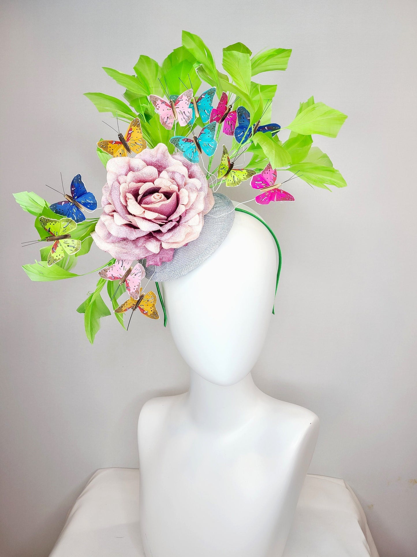 kentucky derby hat fascinator bright green feathers with mauve light pink rose rainbow pink yellow green blue decor and butterflies