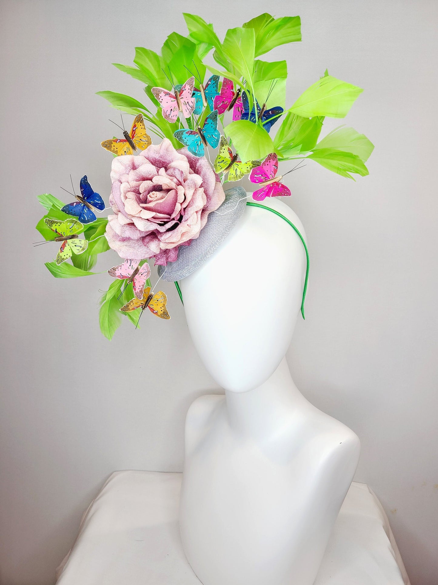 kentucky derby hat fascinator bright green feathers with mauve light pink rose rainbow pink yellow green blue decor and butterflies