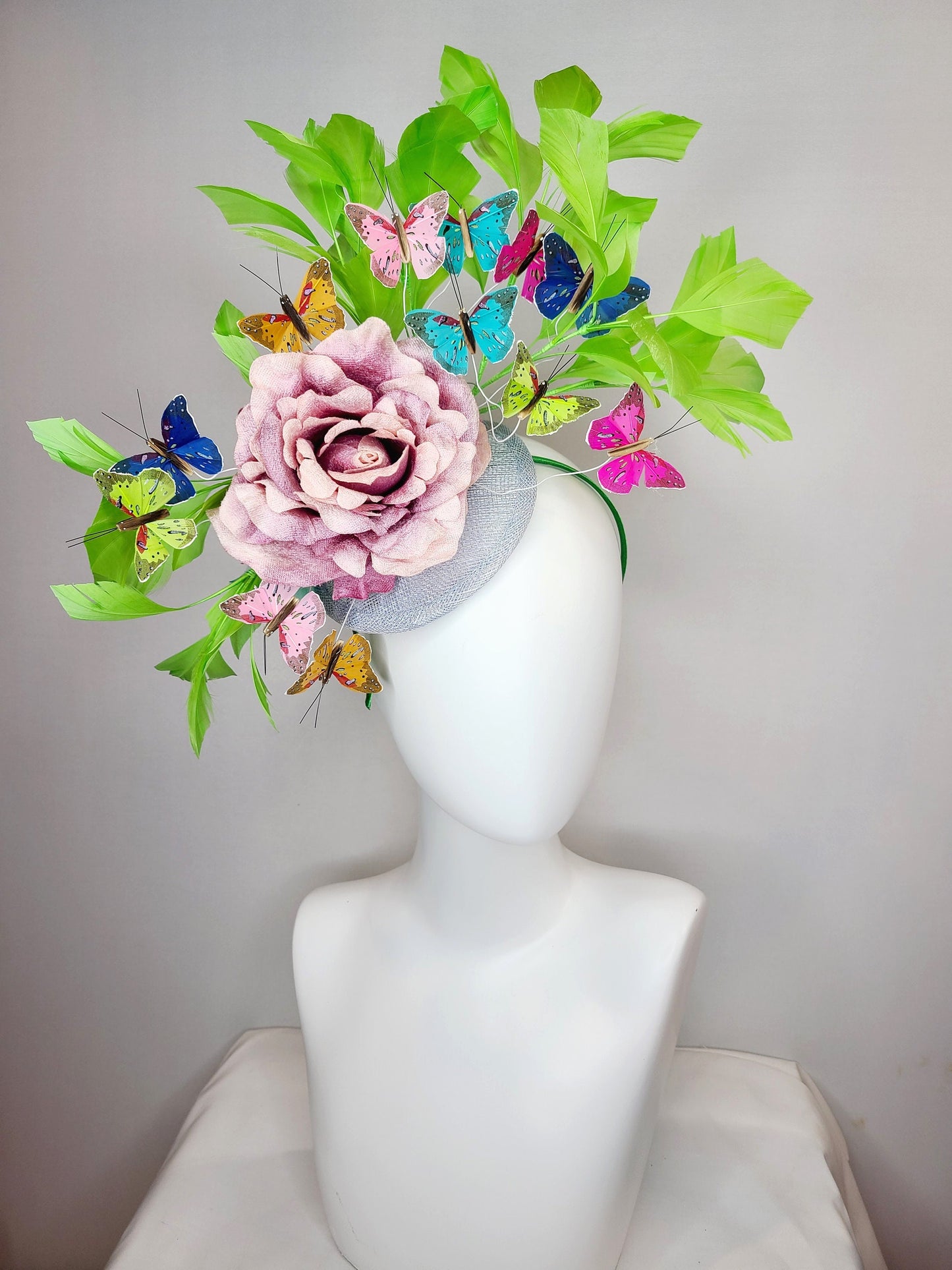 kentucky derby hat fascinator bright green feathers with mauve light pink rose rainbow pink yellow green blue decor and butterflies