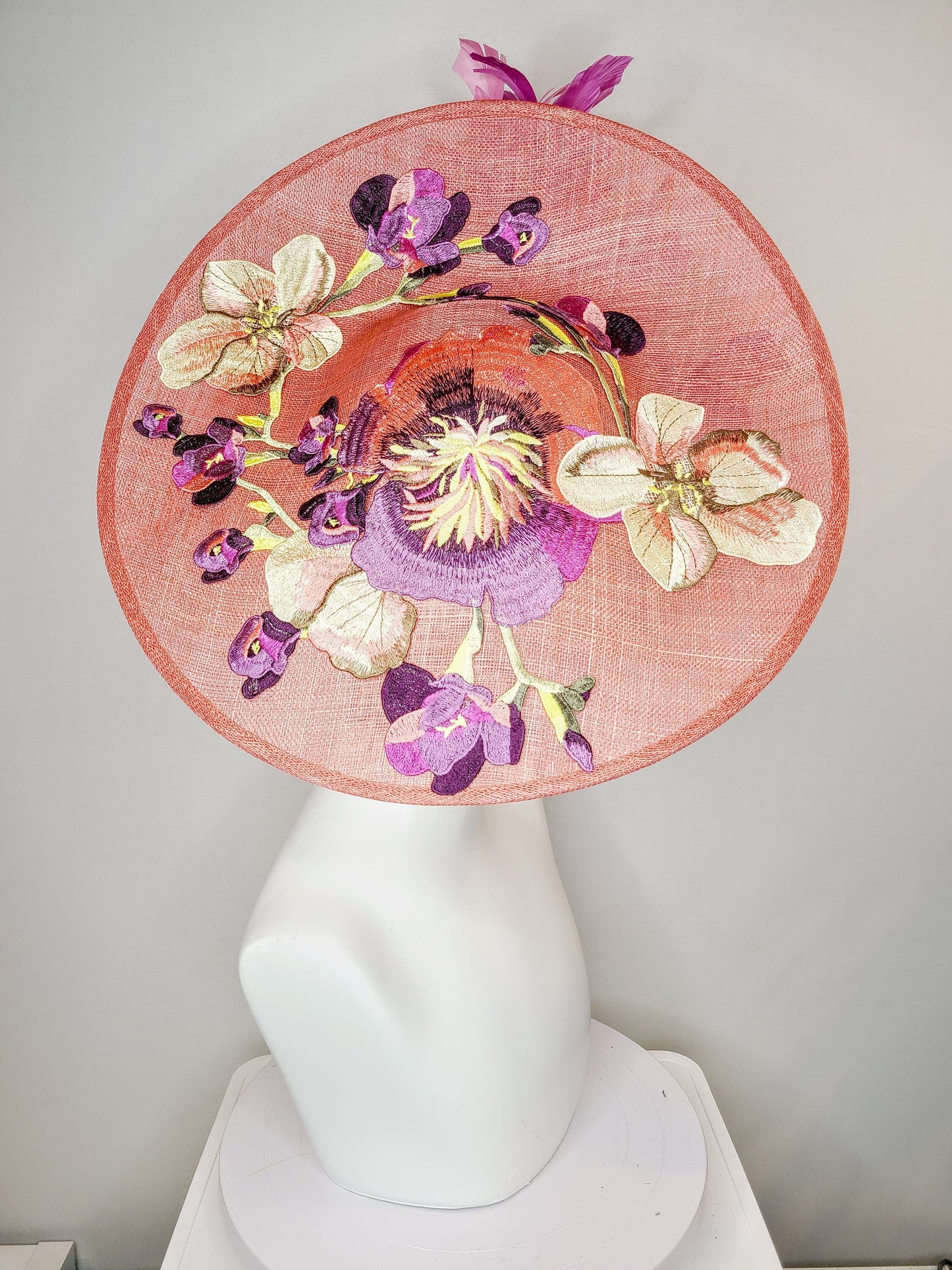 kentucky derby hat fascinator coral pink peach sinamay saucer fascinator with embroidered pink purple gold flowers with pink purple feathers