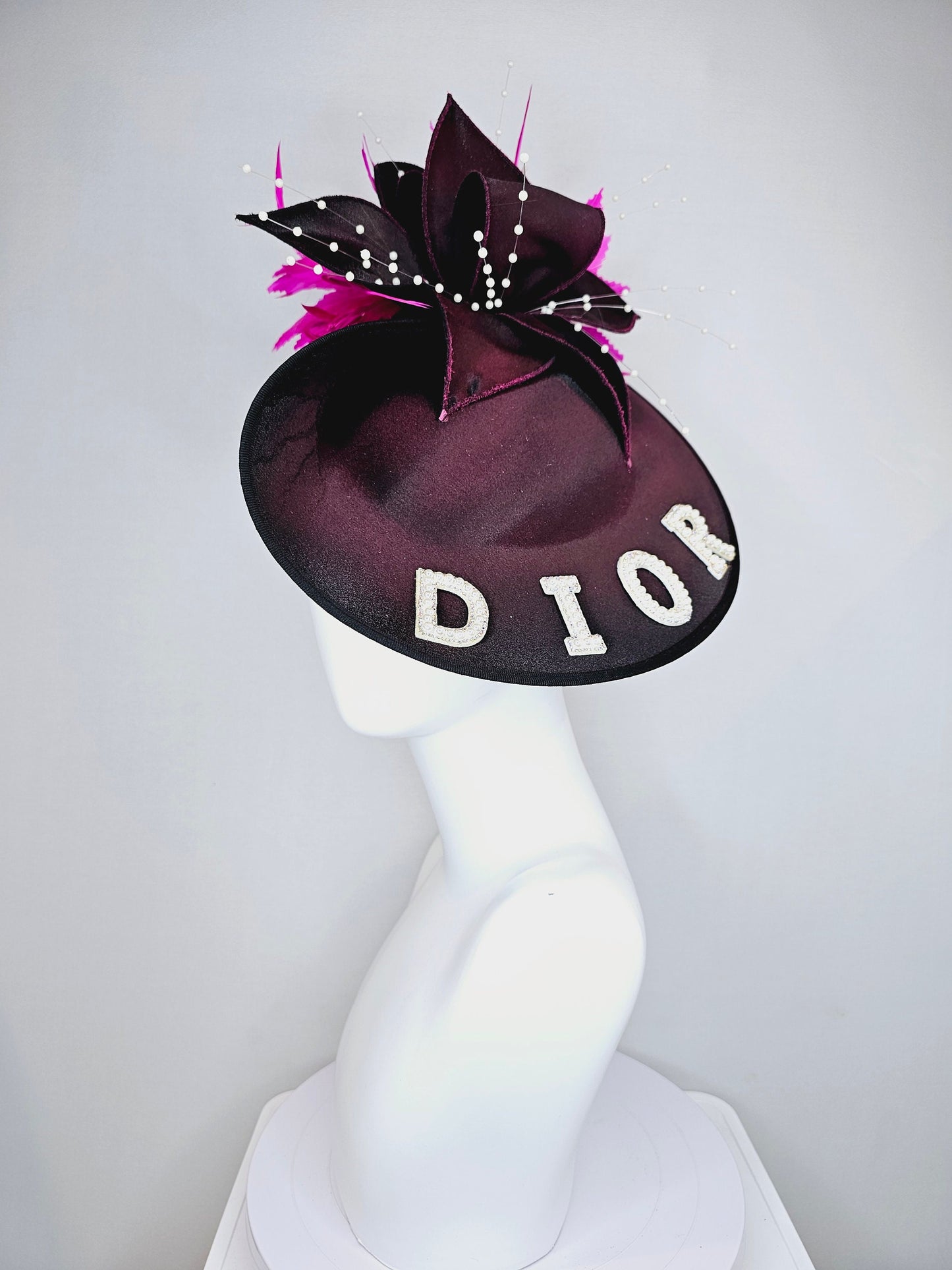 kentucky derby hat fascinator black satin saucer with airbrush pink and white letter decor pink feathers white pearls