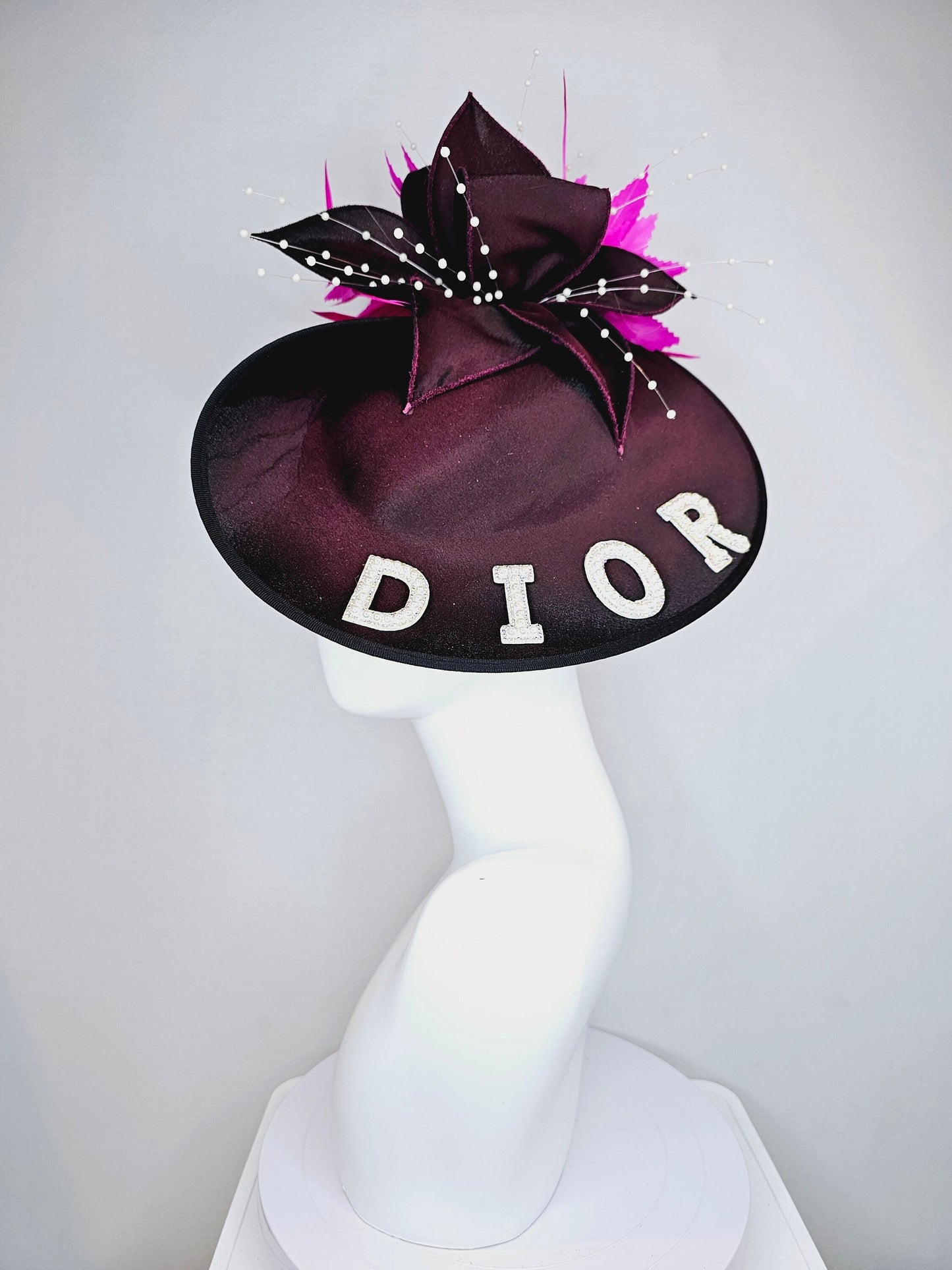 kentucky derby hat fascinator black satin saucer with airbrush pink and white letter decor pink feathers white pearls