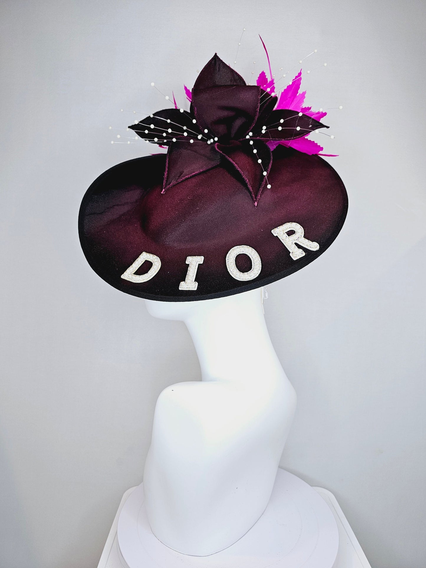 kentucky derby hat fascinator black satin saucer with airbrush pink and white letter decor pink feathers white pearls