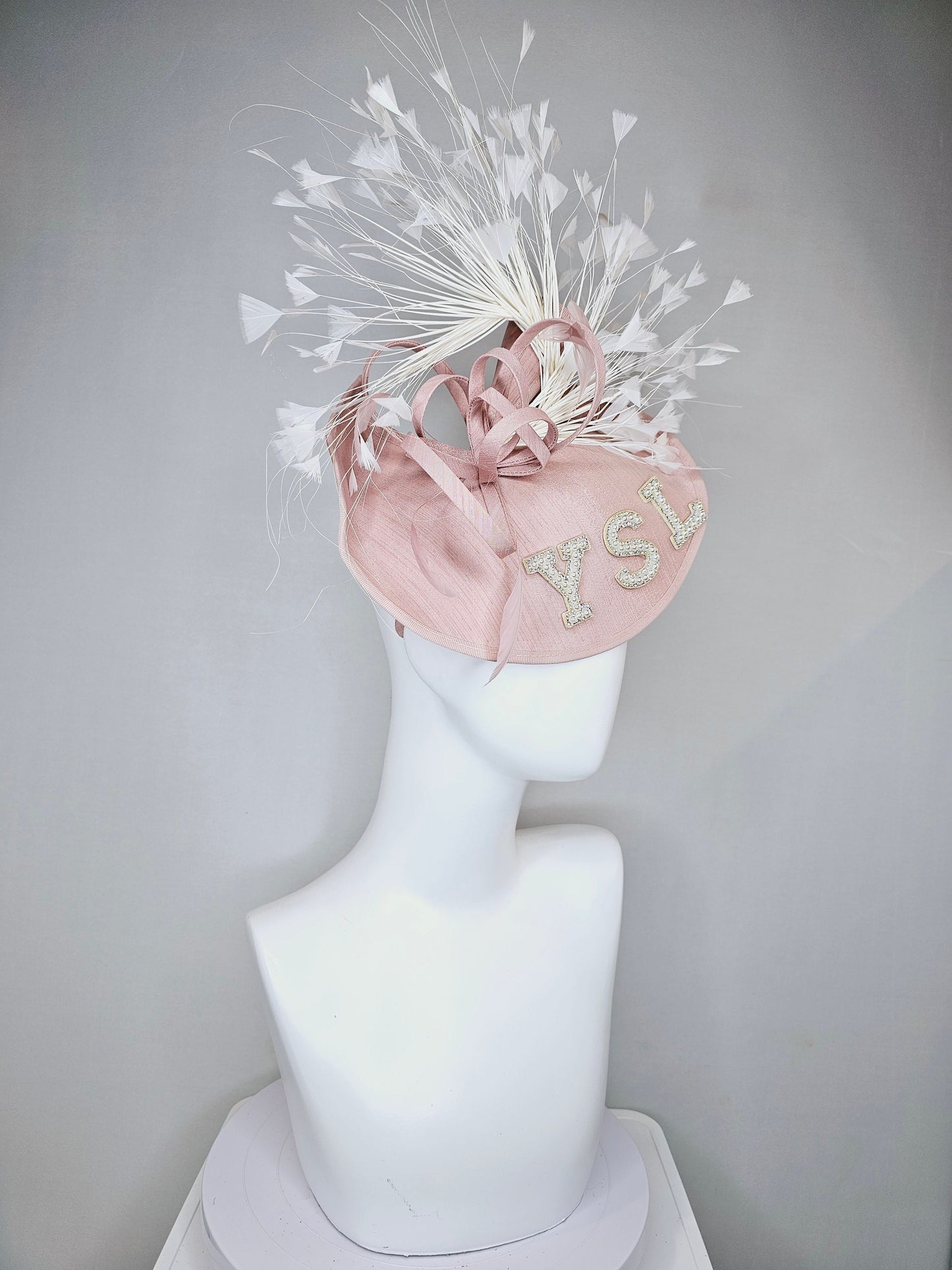 kentucky derby hat fascinator dusty rose blush silk like saucer with white feathers and beaded pearl letters