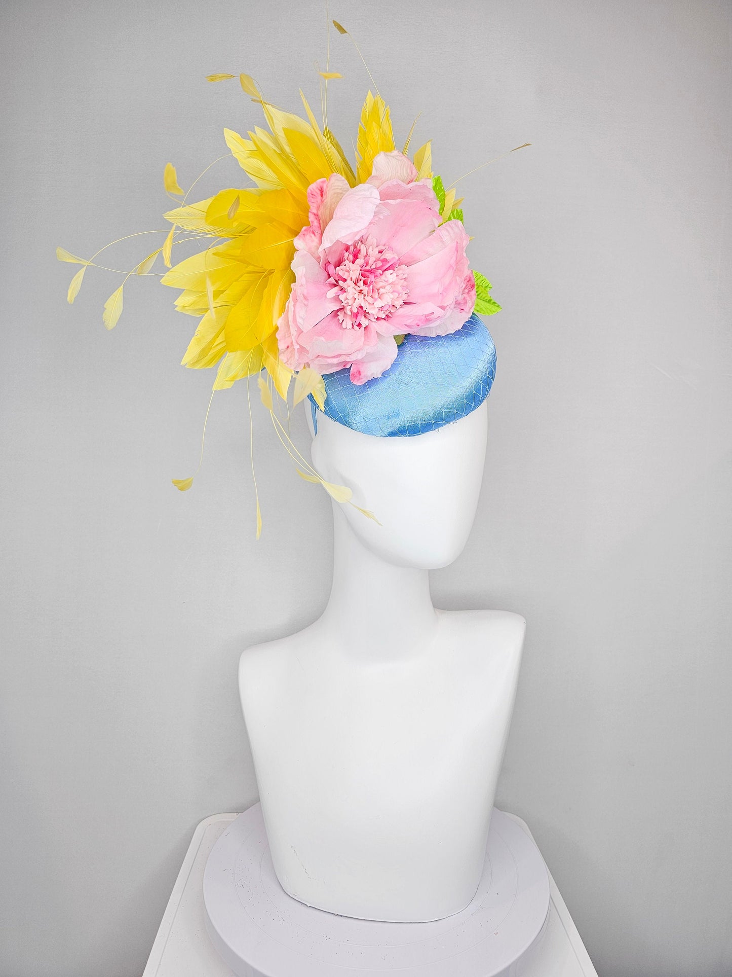 kentucky derby hat fascinator light blue satin with large light pink flowers bright green leaves and yellow feathers