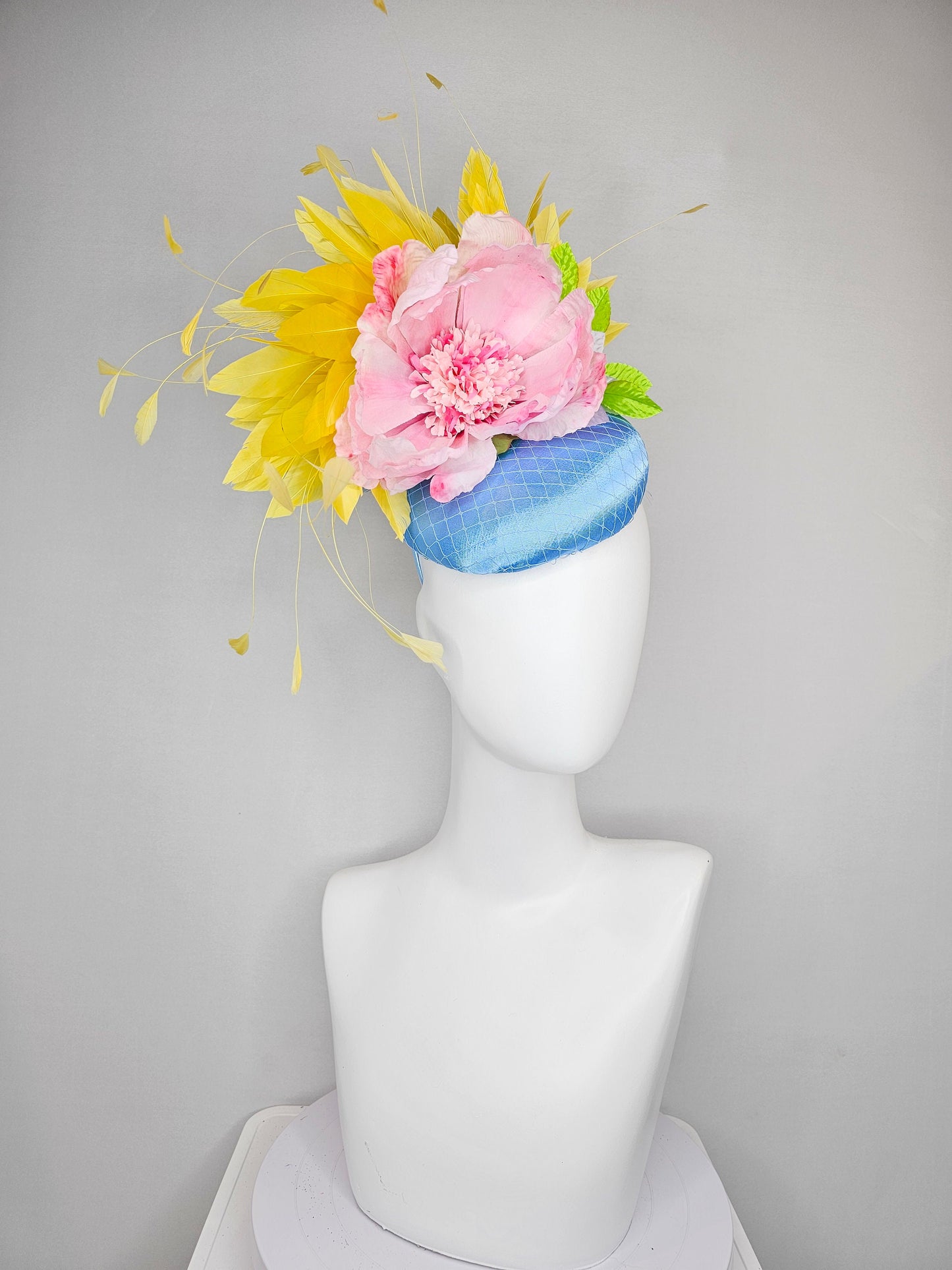 kentucky derby hat fascinator light blue satin with large light pink flowers bright green leaves and yellow feathers