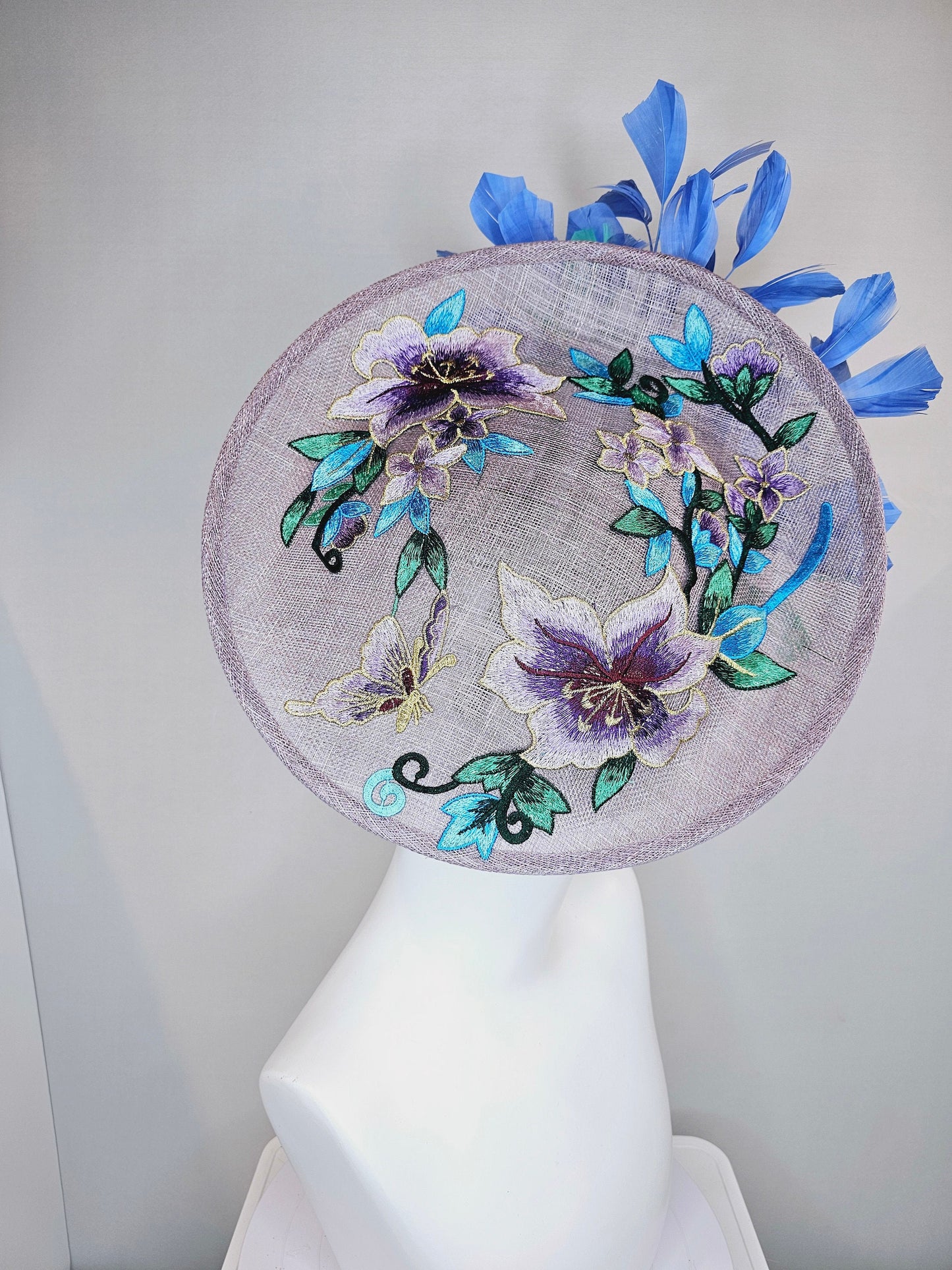 kentucky derby hat fascinator light purple lavender sinamay saucer with blue green feathers and blue green  gold embroidered flowers