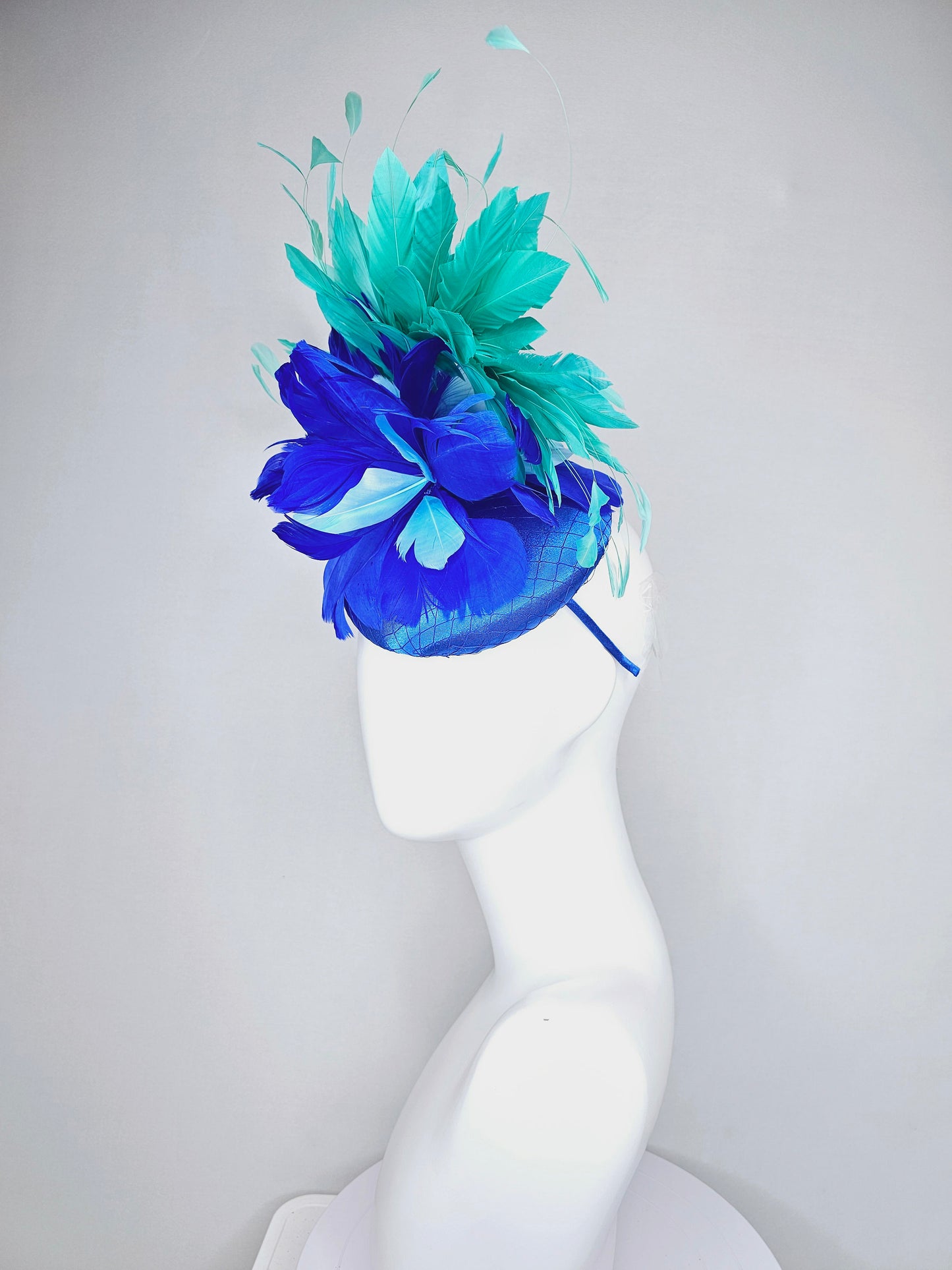 kentucky derby hat fascinator royal blue satin with green feathers and blue green feather flowers