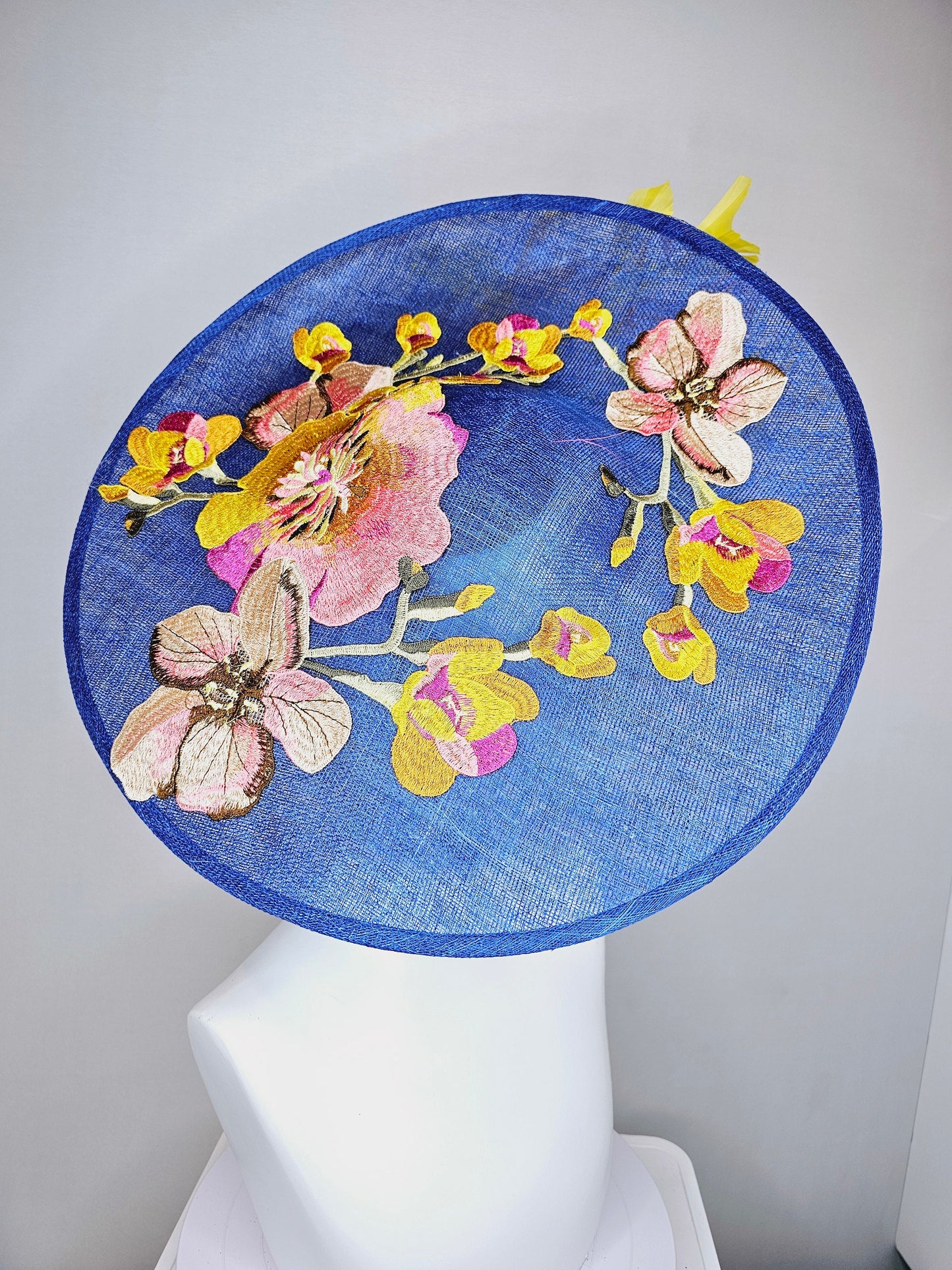 kentucky derby hat fascinator blue sinamay large saucer with yellow and gold taupe feathers and white pink yellow embroidered flowers