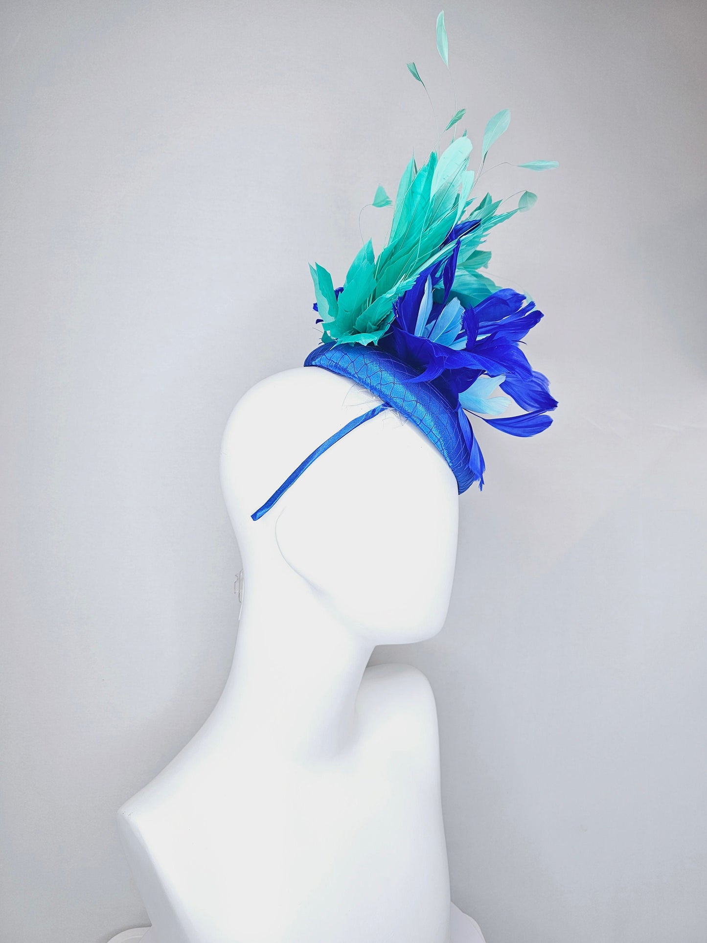 kentucky derby hat fascinator royal blue satin with green feathers and blue green feather flowers