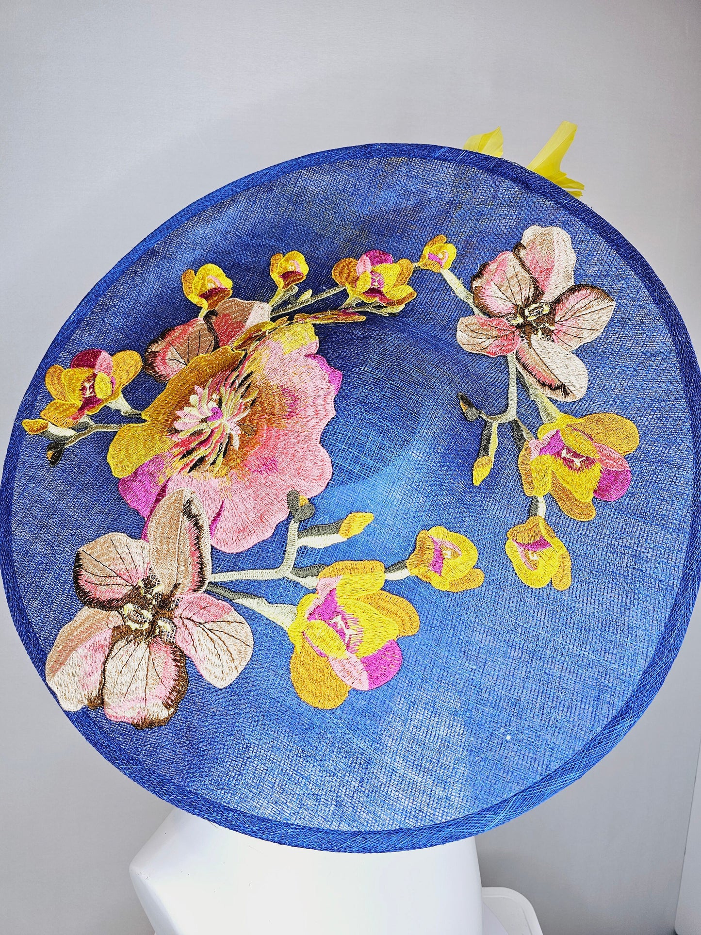 kentucky derby hat fascinator blue sinamay large saucer with yellow and gold taupe feathers and white pink yellow embroidered flowers