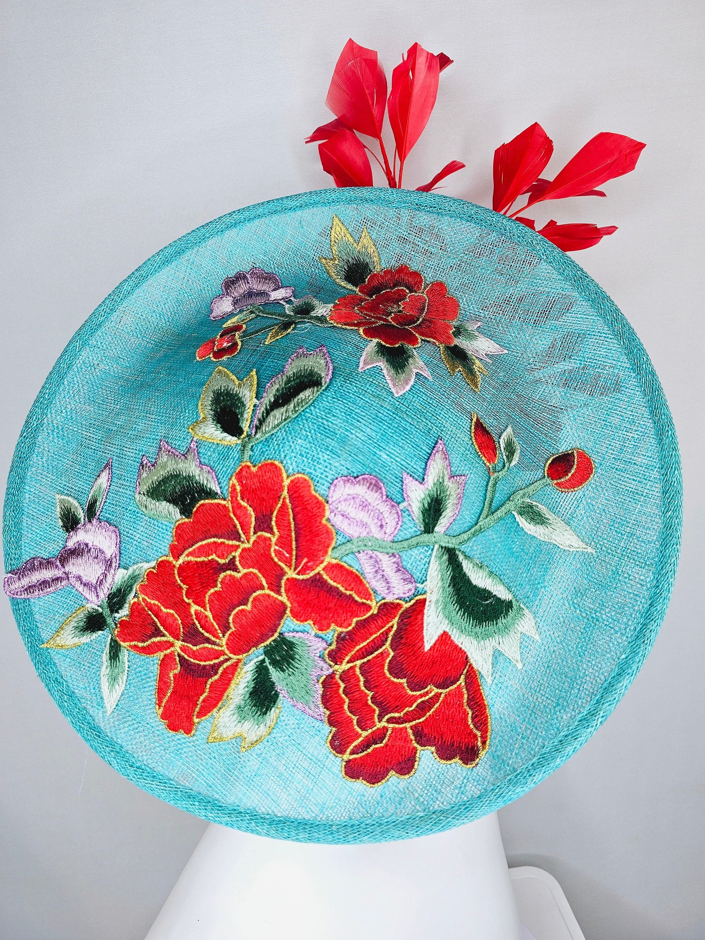 kentucky derby hat fascinator teal turquoise aqua blue sinamay saucer with purple red gold green embroidered flowers with red feathers