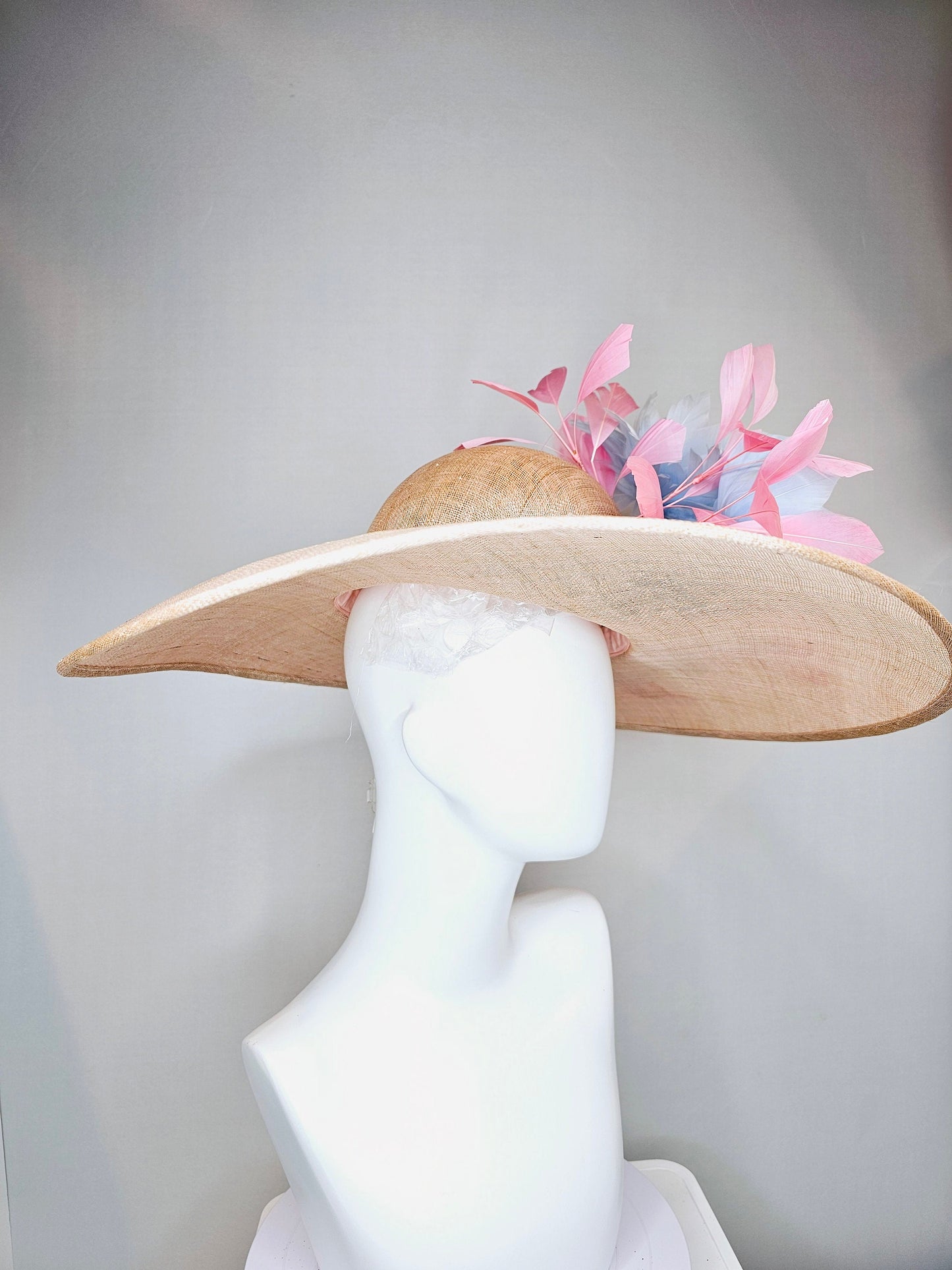 kentucky derby hat large wide brim sinamay neutral beige hat with light baby pink feathers and light baby blue fluffy feather flowers