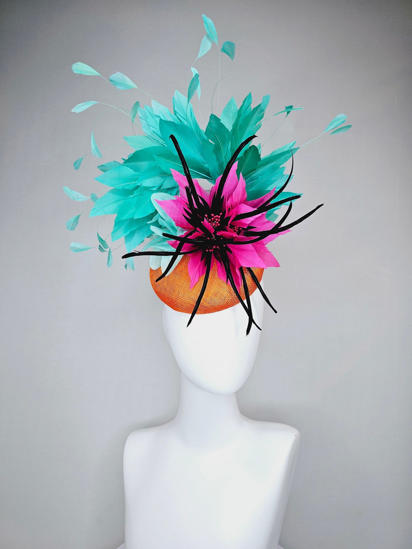 kentucky derby hat fascinator orange sinamay with large hot pink and black feather flowers and turquoise blue branching feathers