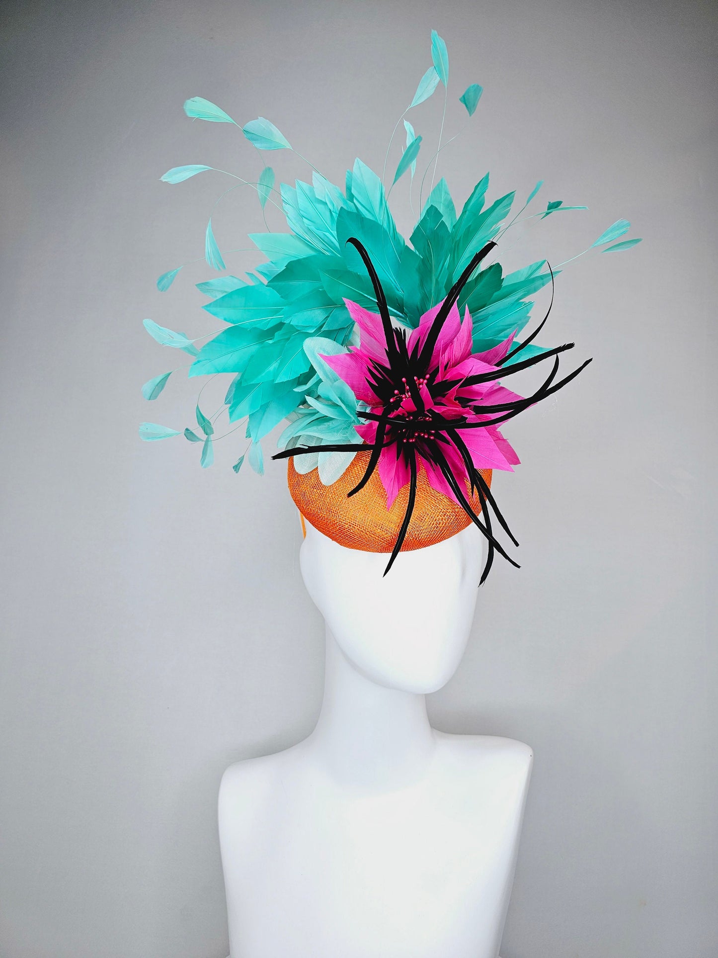 kentucky derby hat fascinator orange sinamay with large hot pink and black feather flowers and turquoise blue branching feathers