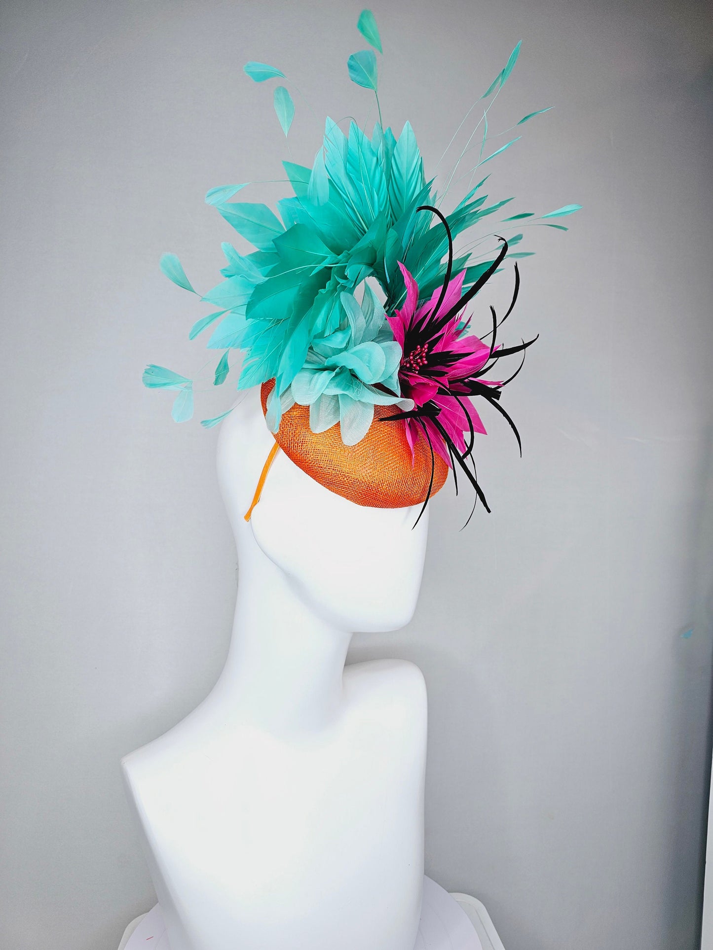 kentucky derby hat fascinator orange sinamay with large hot pink and black feather flowers and turquoise blue branching feathers