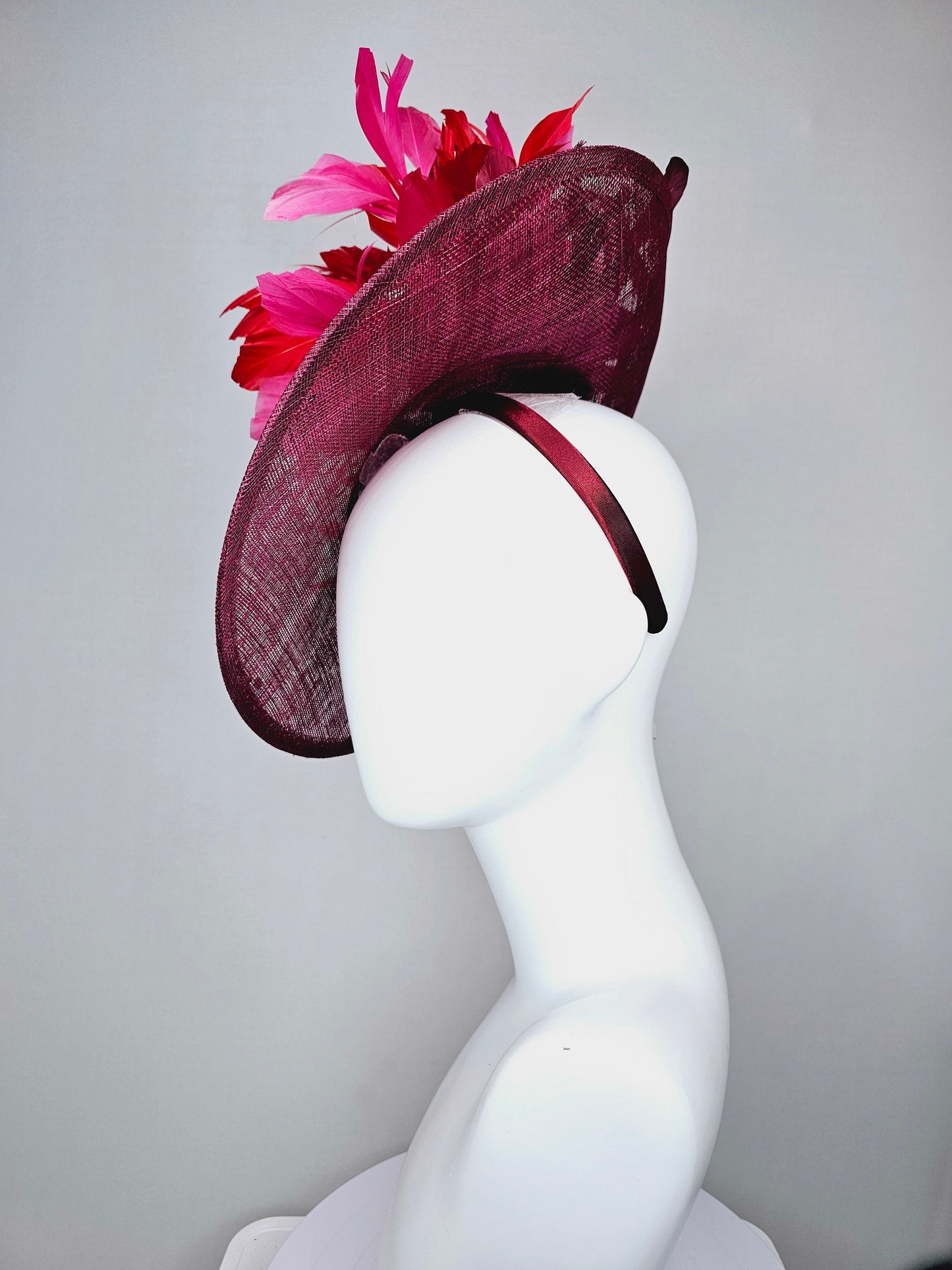 kentucky derby hat fascinator burgundy wine sinamay saucer with matching netting with sequin and red flower feather and hot pink feathers