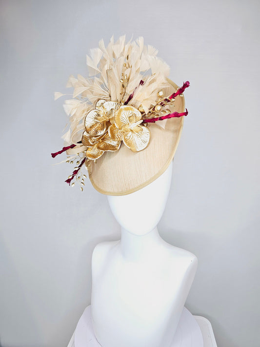 kentucky derby hat fascinator gold taupe beige shantung silk saucer with curls and gold orchids and light tan feathers with burgundy stems