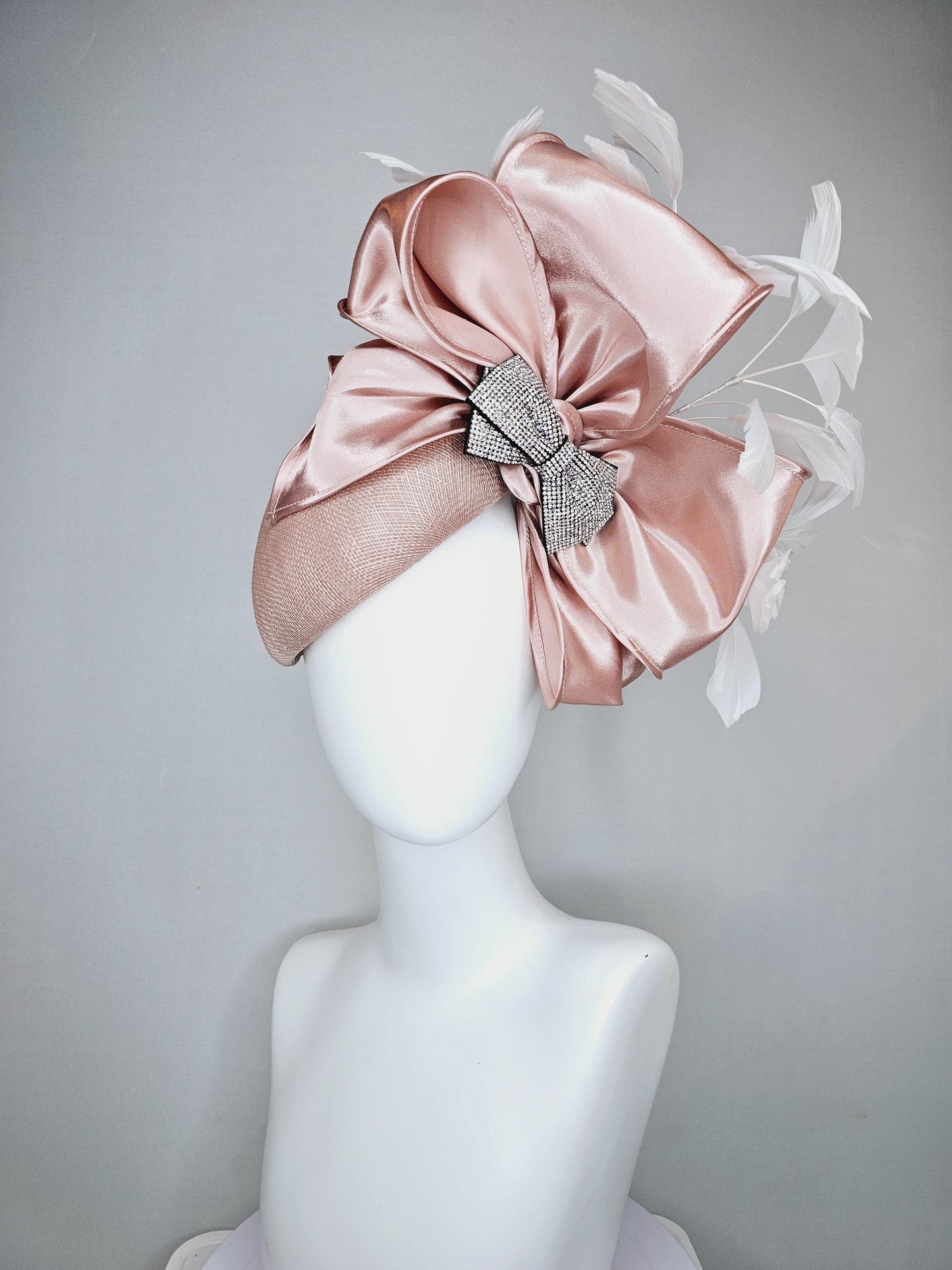 kentucky derby hat fascinator light dusty pink sinamay with satin champagne pink bow with Swarovski crystal bow and branching white feather