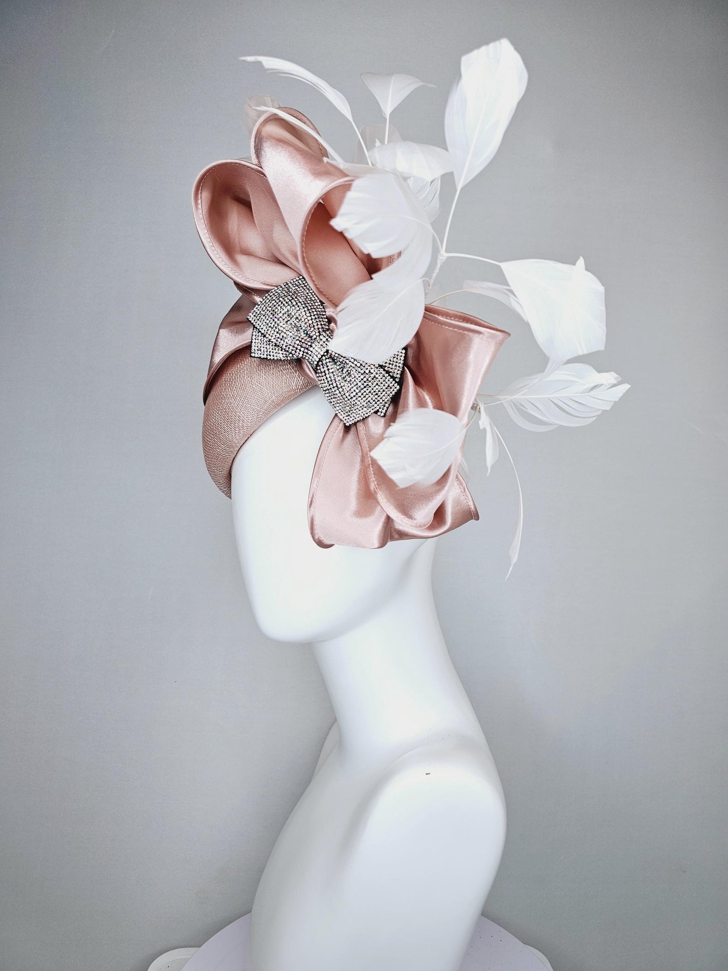 kentucky derby hat fascinator light dusty pink sinamay with satin champagne pink bow with Swarovski crystal bow and branching white feather