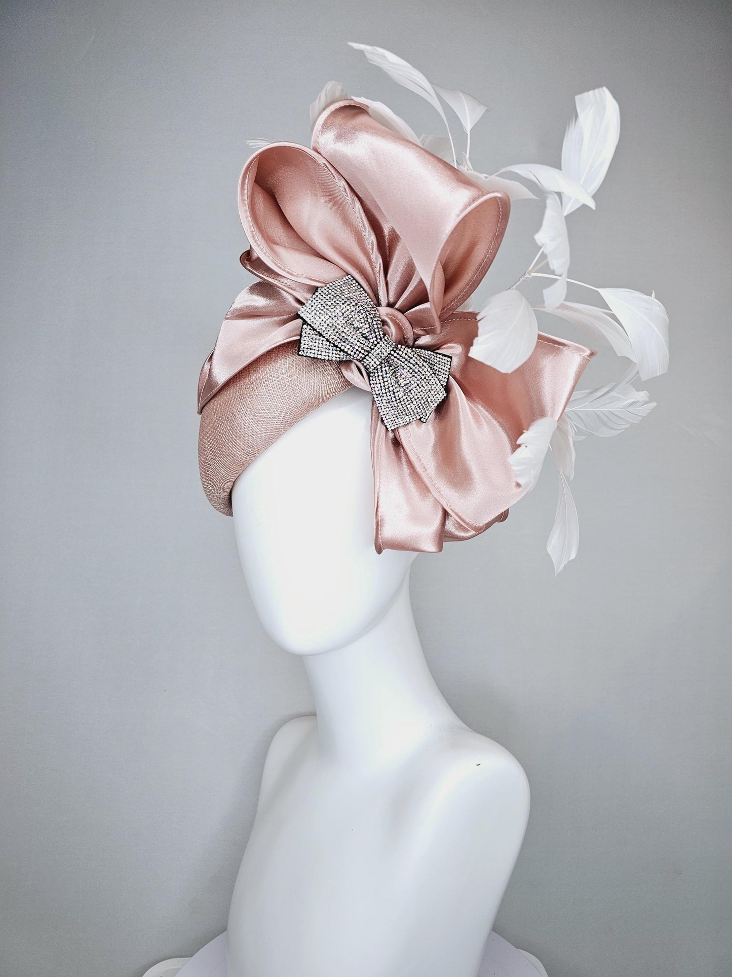 kentucky derby hat fascinator light dusty pink sinamay with satin champagne pink bow with Swarovski crystal bow and branching white feather