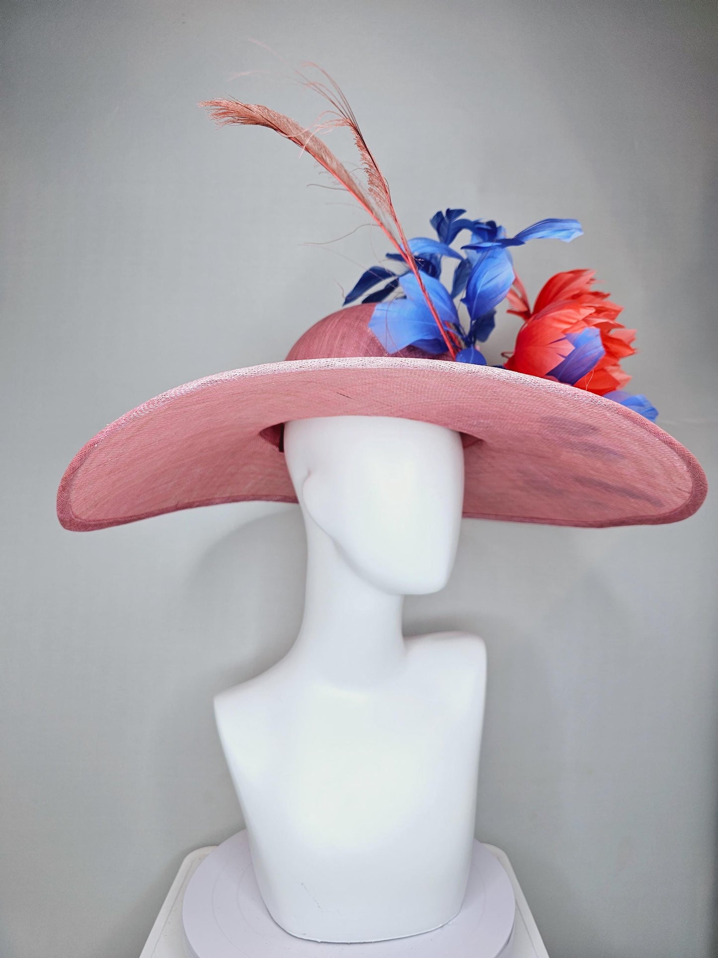 kentucky derby hat large wide brim sinamay blush pink hat with large orange coral feather flowers and royal blue branching feathers