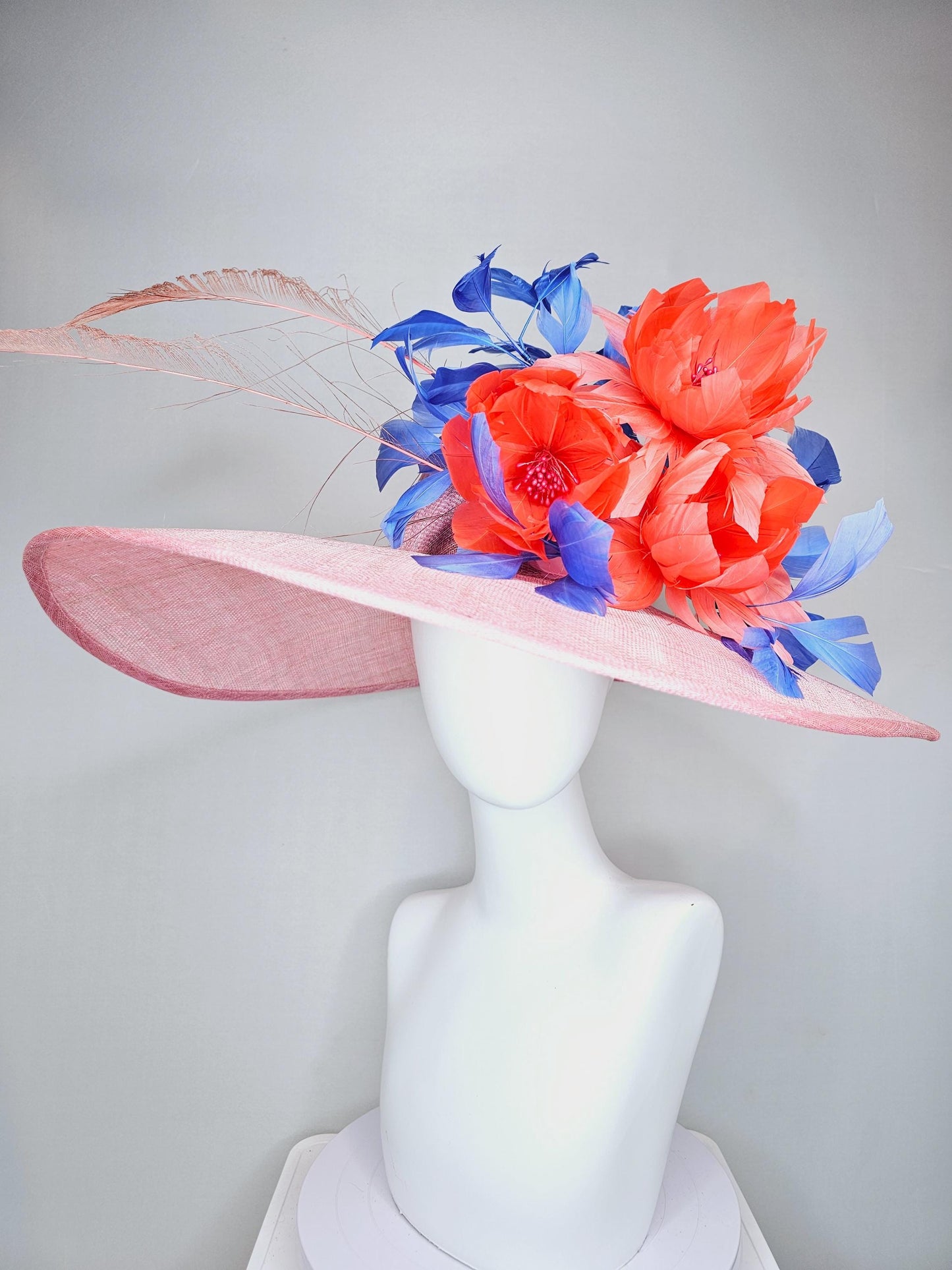 kentucky derby hat large wide brim sinamay blush pink hat with large orange coral feather flowers and royal blue branching feathers