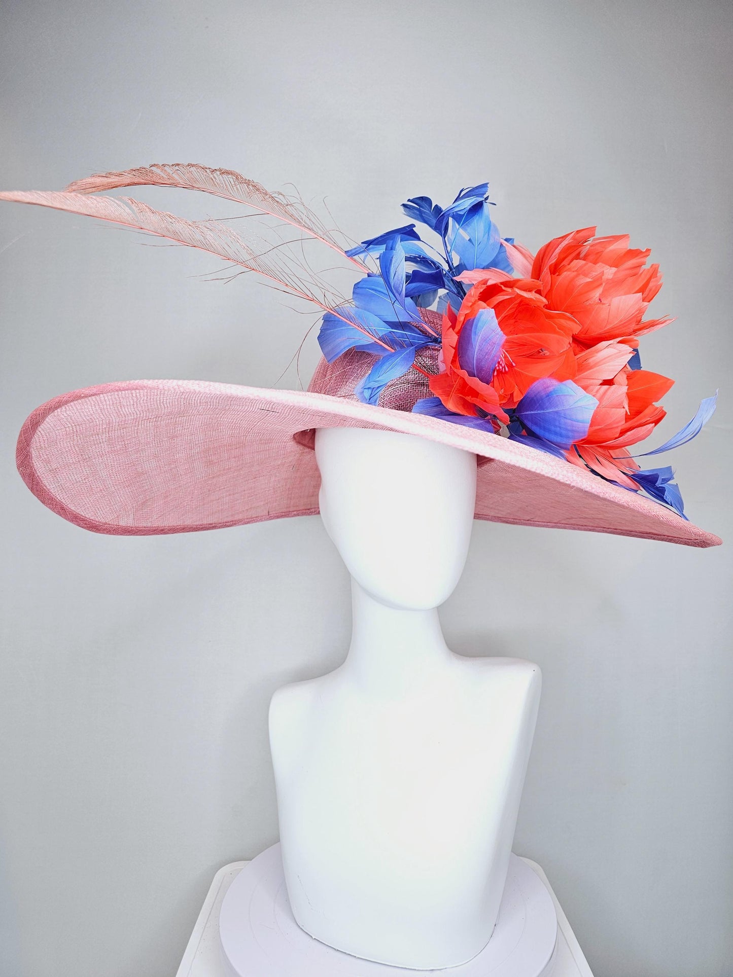 kentucky derby hat large wide brim sinamay blush pink hat with large orange coral feather flowers and royal blue branching feathers