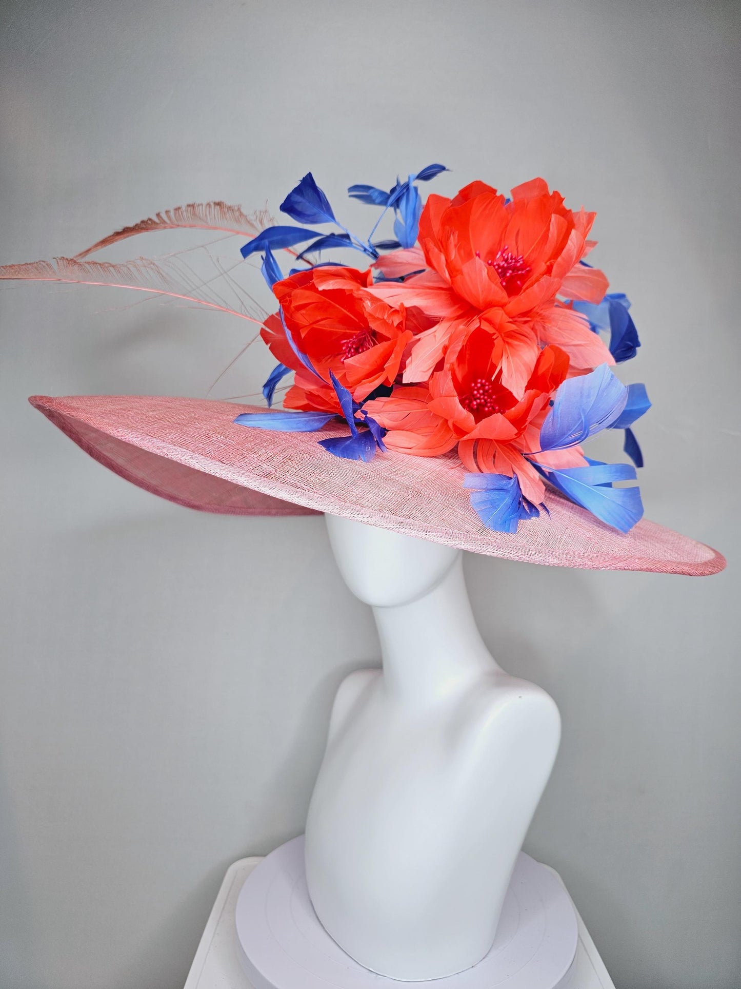 kentucky derby hat large wide brim sinamay blush pink hat with large orange coral feather flowers and royal blue branching feathers