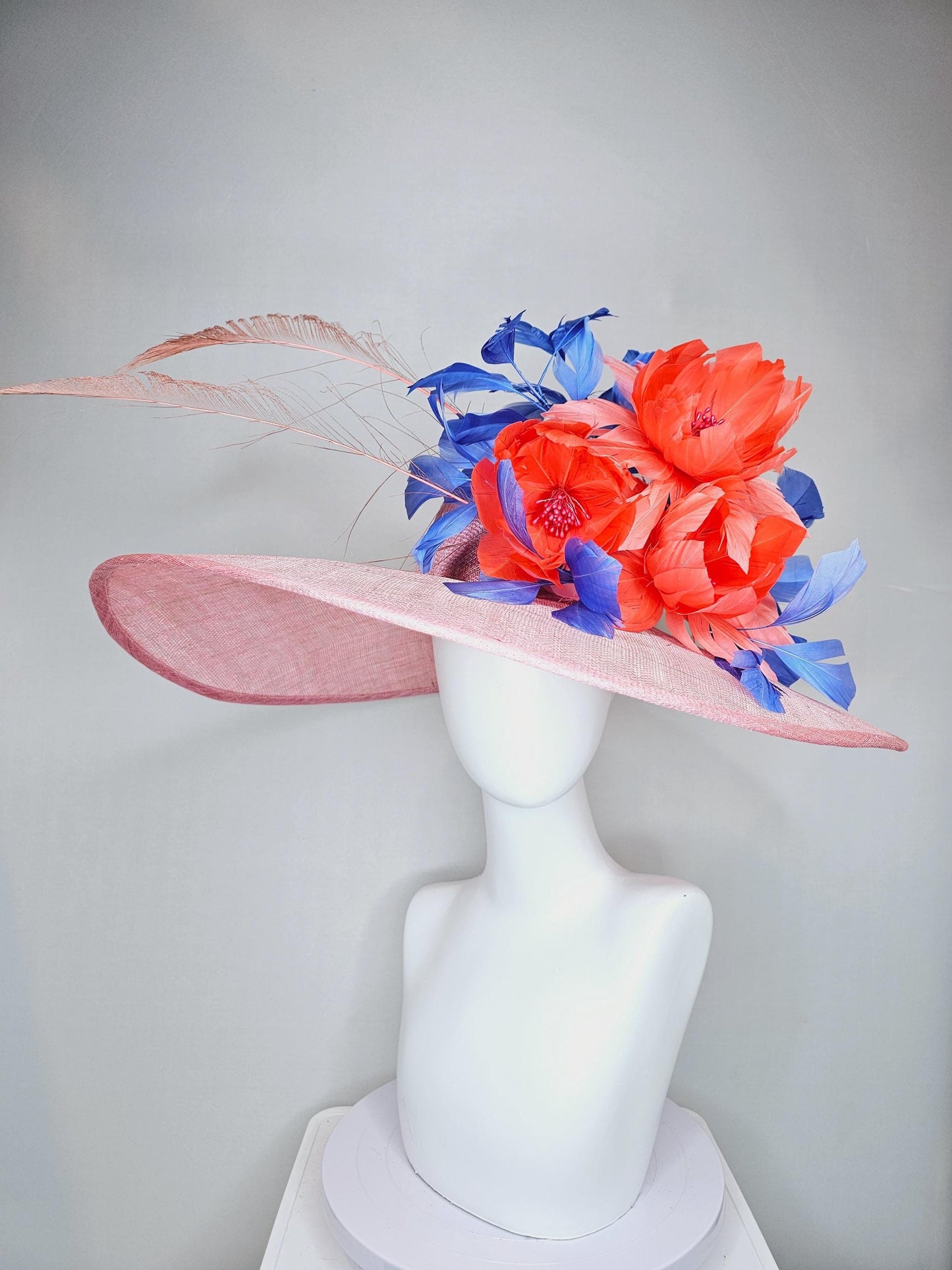 kentucky derby hat large wide brim sinamay blush pink hat with large orange coral feather flowers and royal blue branching feathers