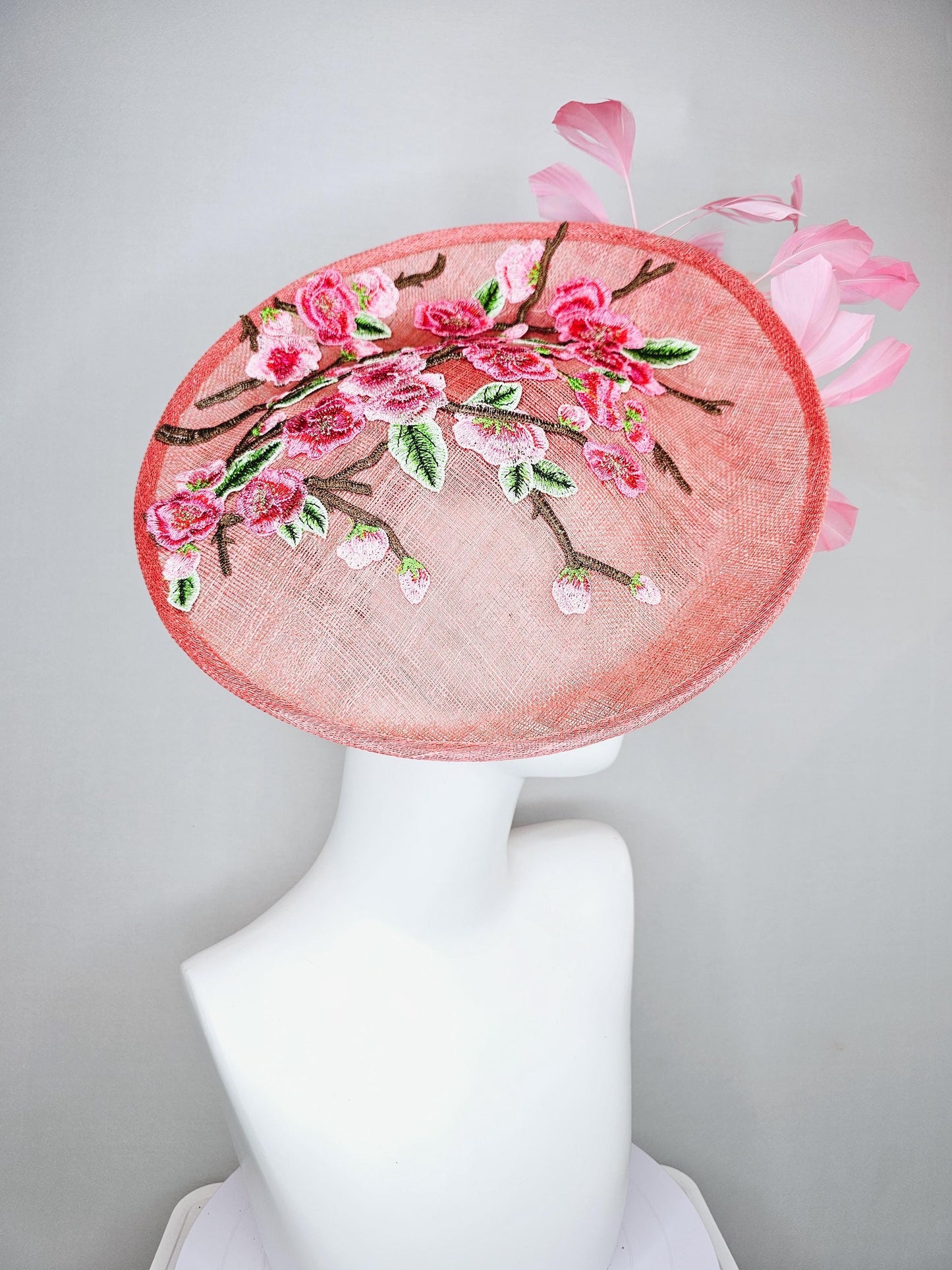 kentucky derby hat fascinator coral peach sinamay saucer with pink green brown floral embroidery,light pink and green branching feathers