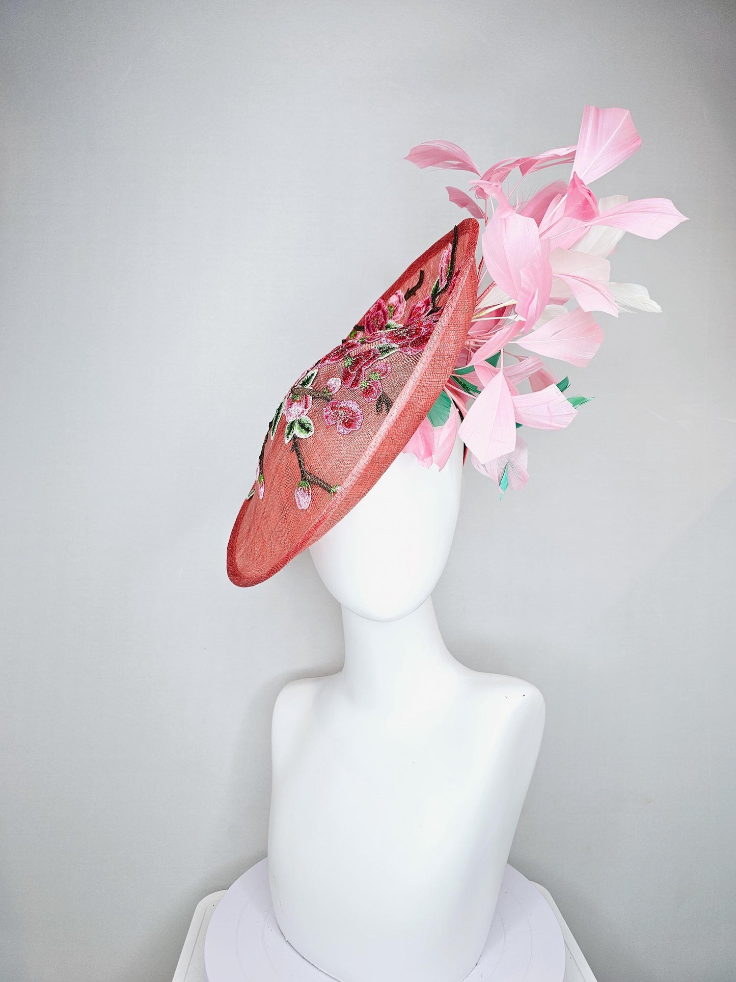 kentucky derby hat fascinator coral peach sinamay saucer with pink green brown floral embroidery,light pink and green branching feathers