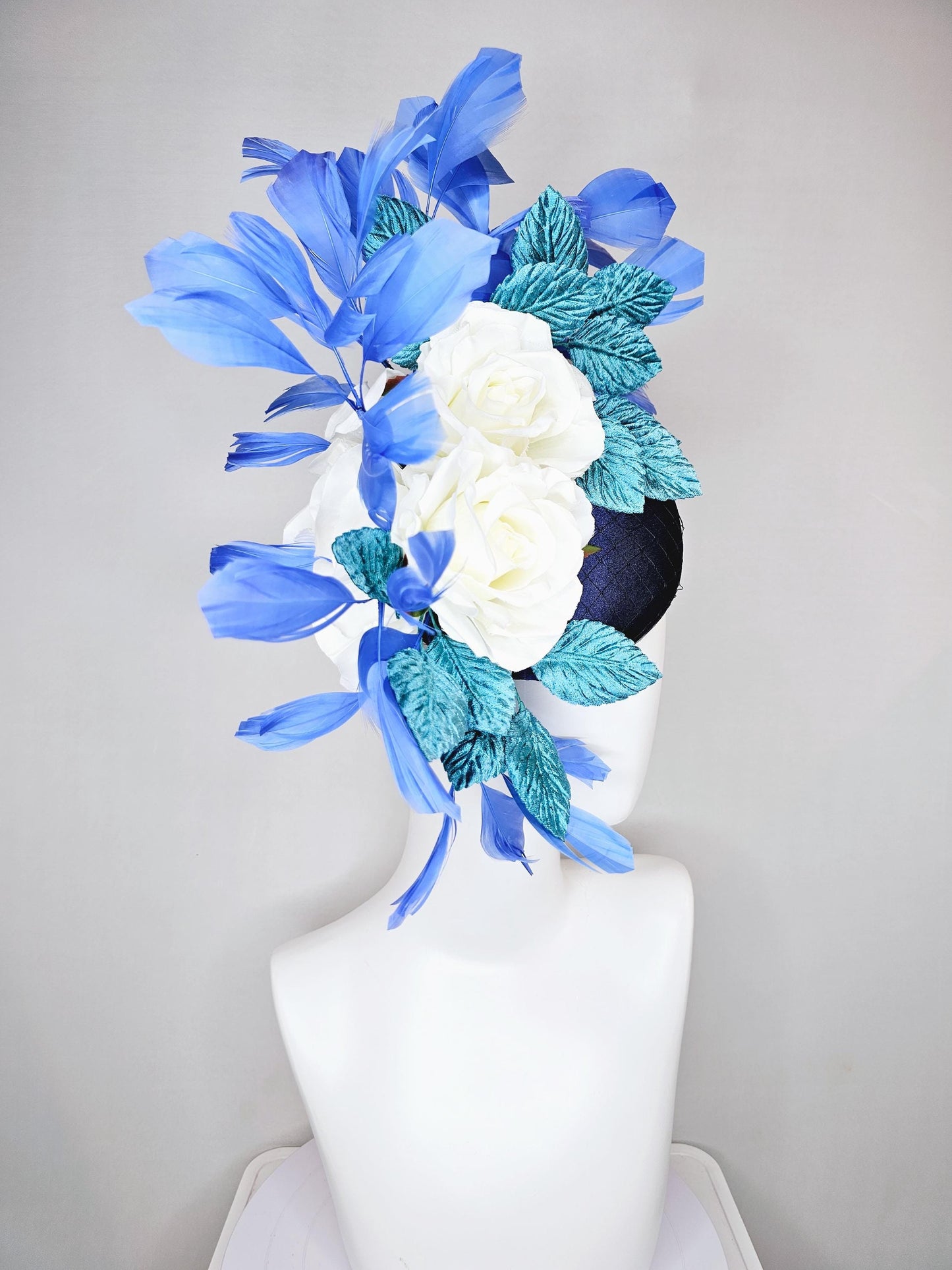 kentucky derby hat fascinator midnight navy blue satin with white silk flowers,teal blue velvet leaves,and royal blue branching feathers