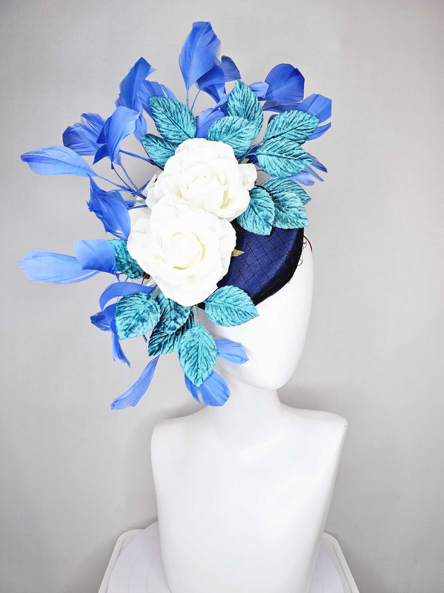 kentucky derby hat fascinator midnight navy blue satin with white silk flowers,teal blue velvet leaves,and royal blue branching feathers